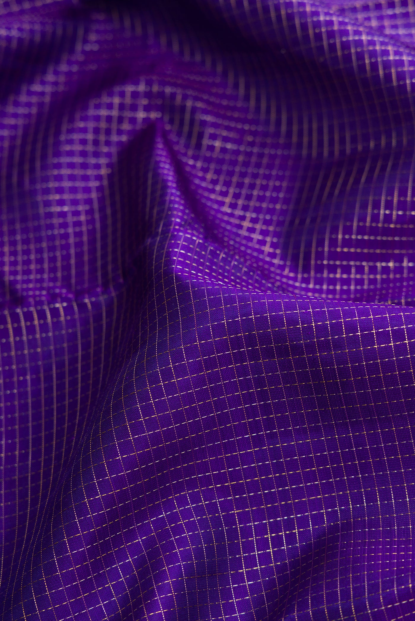 Close up of Violet Dual Tone Kanjivaram Silk Saree with Checked design on the body and Fancy Border.  displaying folds