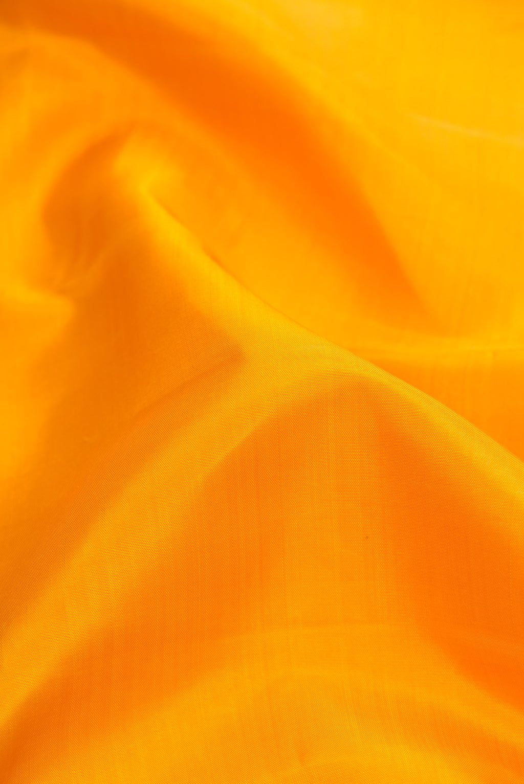 Close up of Pure Silk Pure Zari Yellow Dual Tone Kanjivaram Saree with Plain Body and Zari Border.  displaying folds