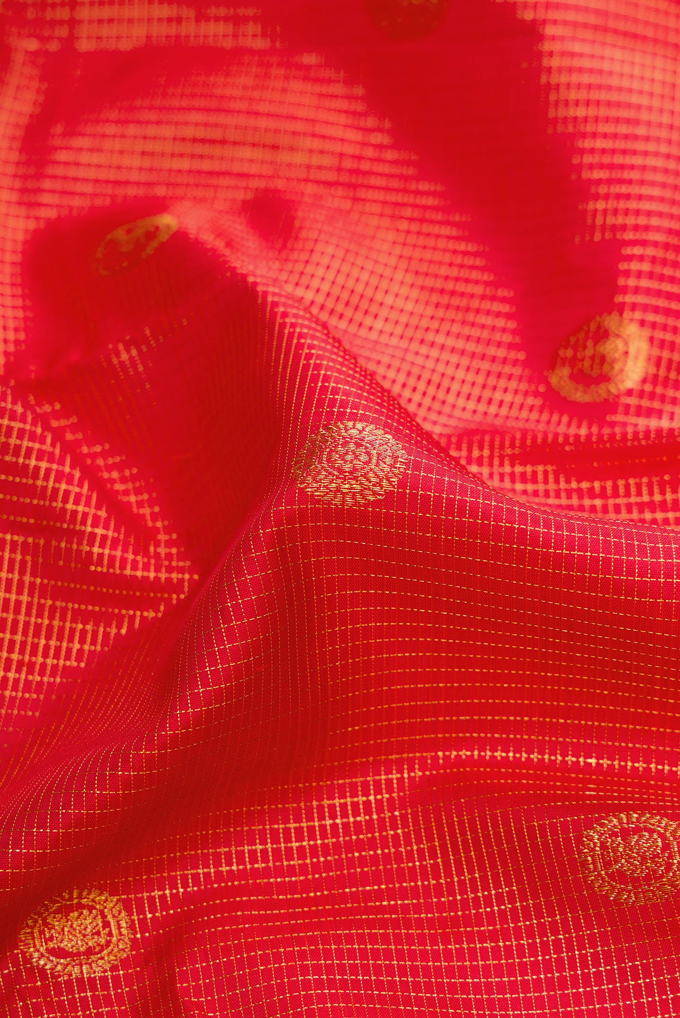 Close up of Red Dual Tone Kanchipuram Silk Saree with Checked design on the body and Zari Border.  displaying folds