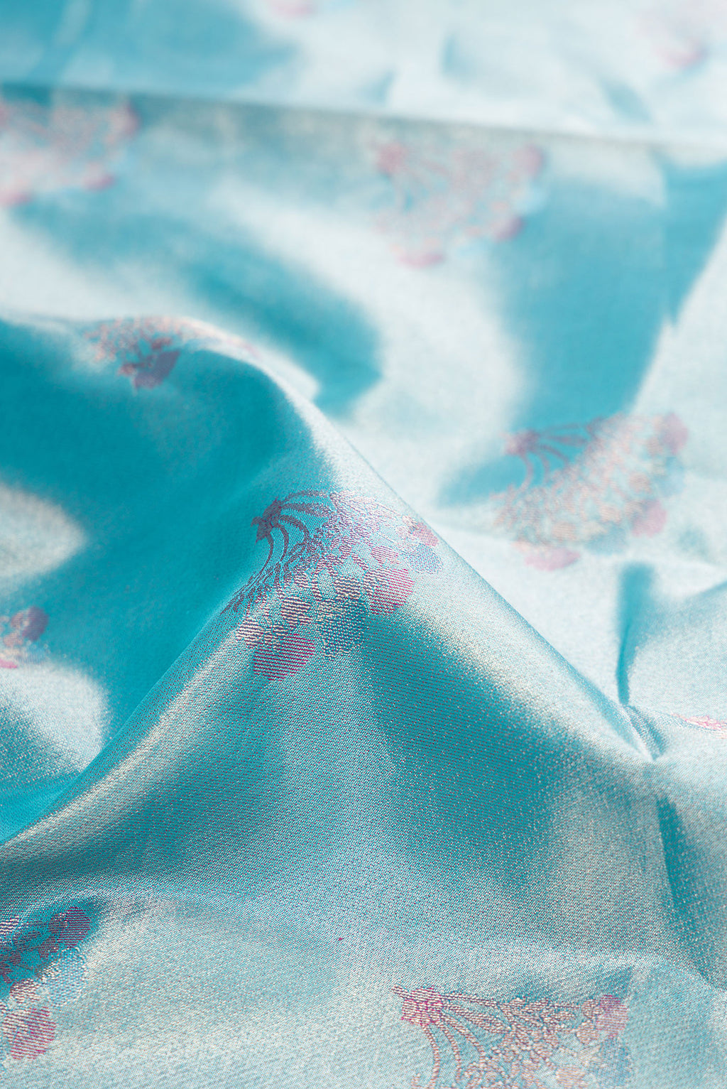 Close up of Sky Blue Dual Tone Kanjivaram Tissue Silk Saree with Zari Brocade on the body and Fancy Border.  displaying folds