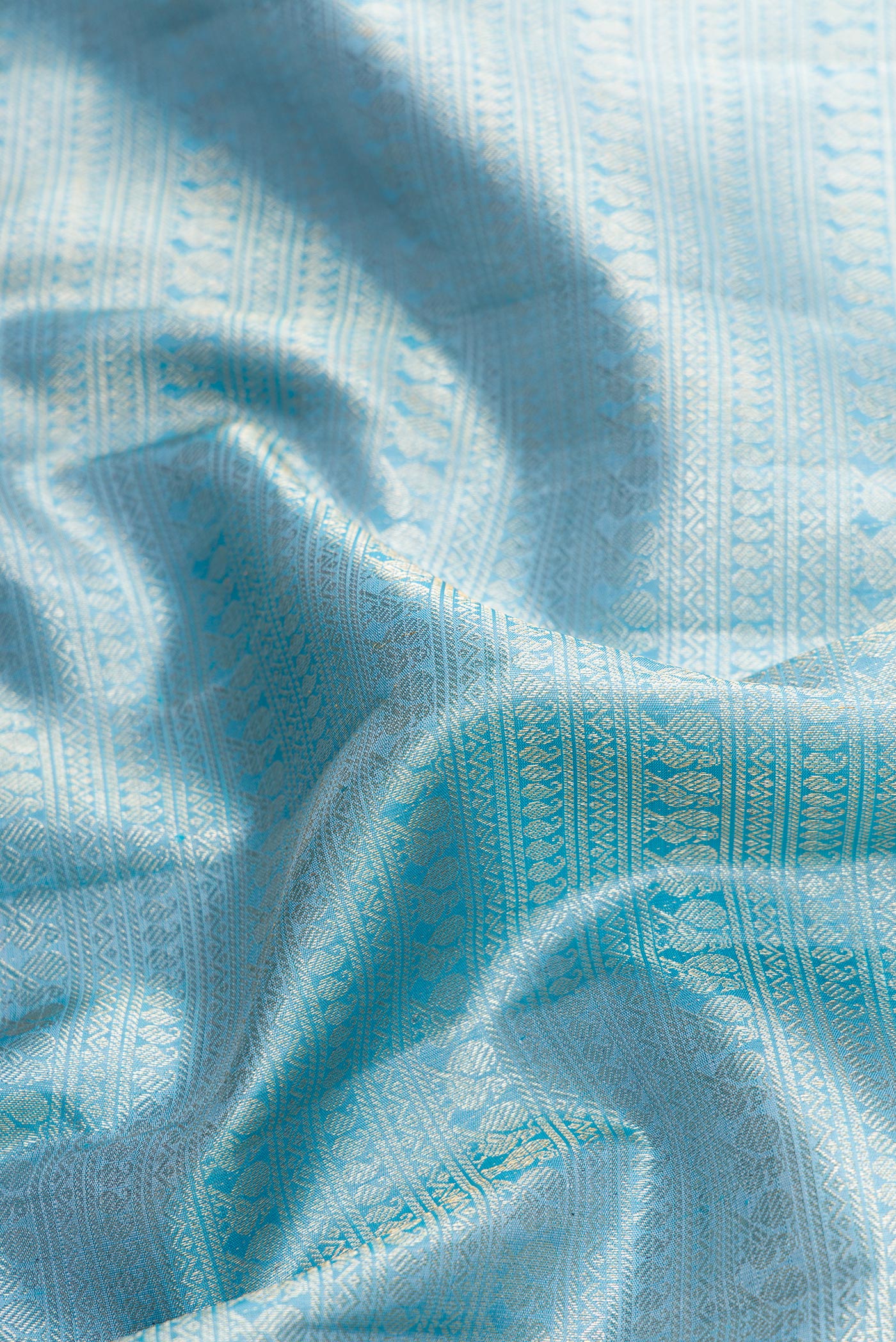 Close up of Sky Blue Dual Tone Kanchipuram Silk Saree with Zari Brocade on the body and Zari Border.  displaying folds