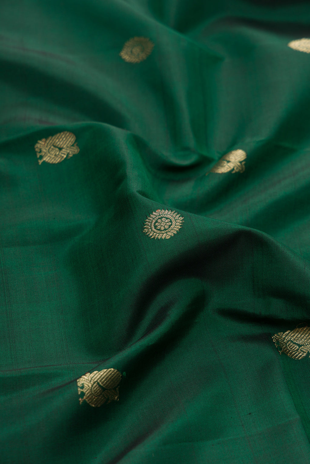 Close up of Bottle Green Kanjivaram Silk Saree with Zari Butta on the body and Checks Border.  displaying folds