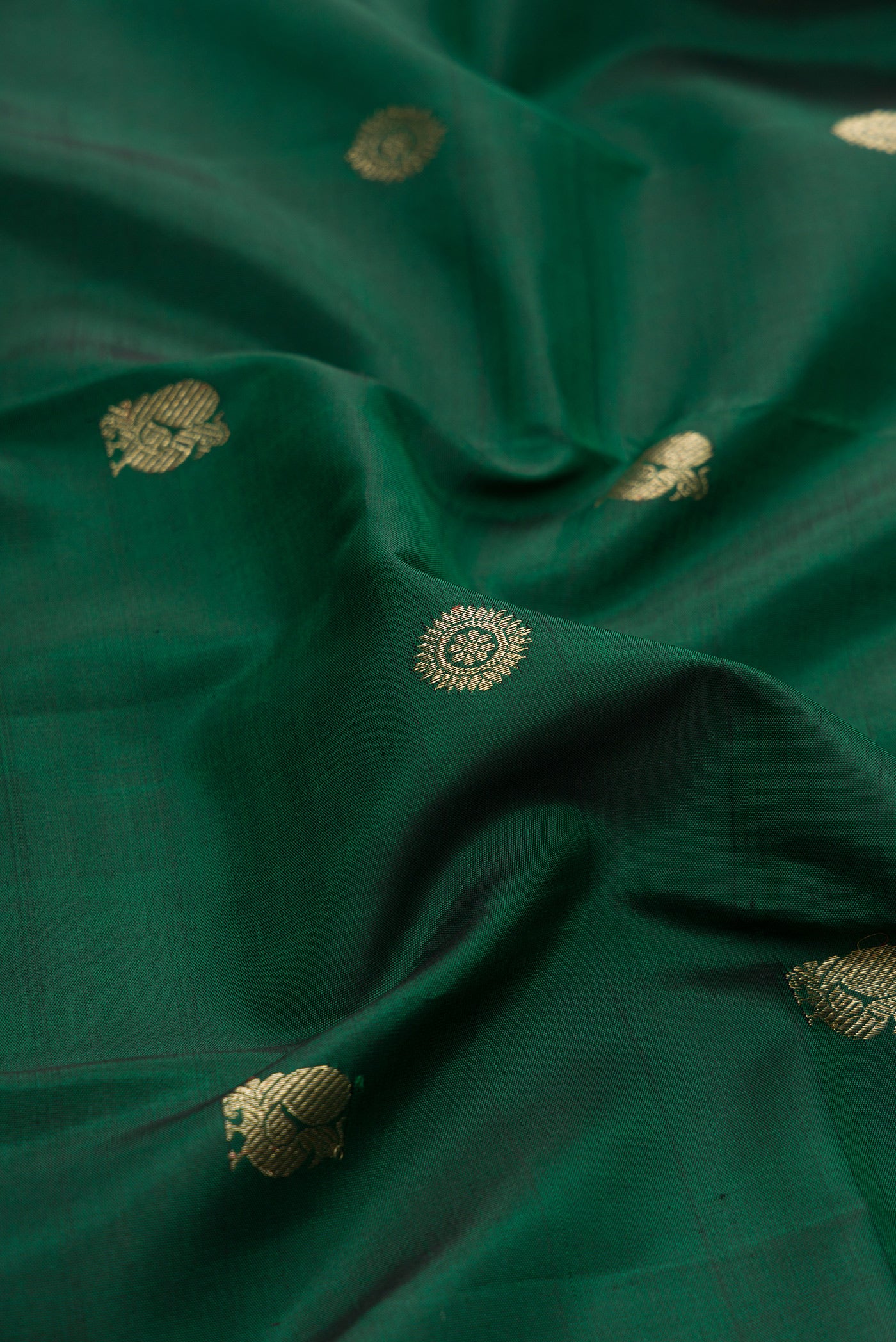 Close up of Bottle Green Kanjivaram Silk Saree with Zari Butta on the body and Checks Border.  displaying folds