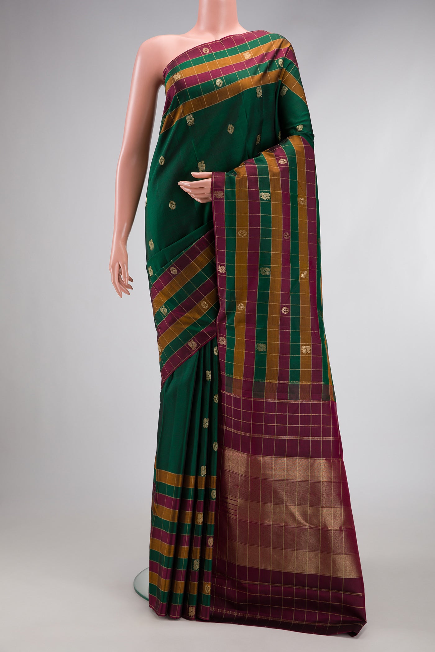 Bottle Green Kanjivaram Silk Saree with Zari Butta on the body and Checks Border.  displayed on a mannequin