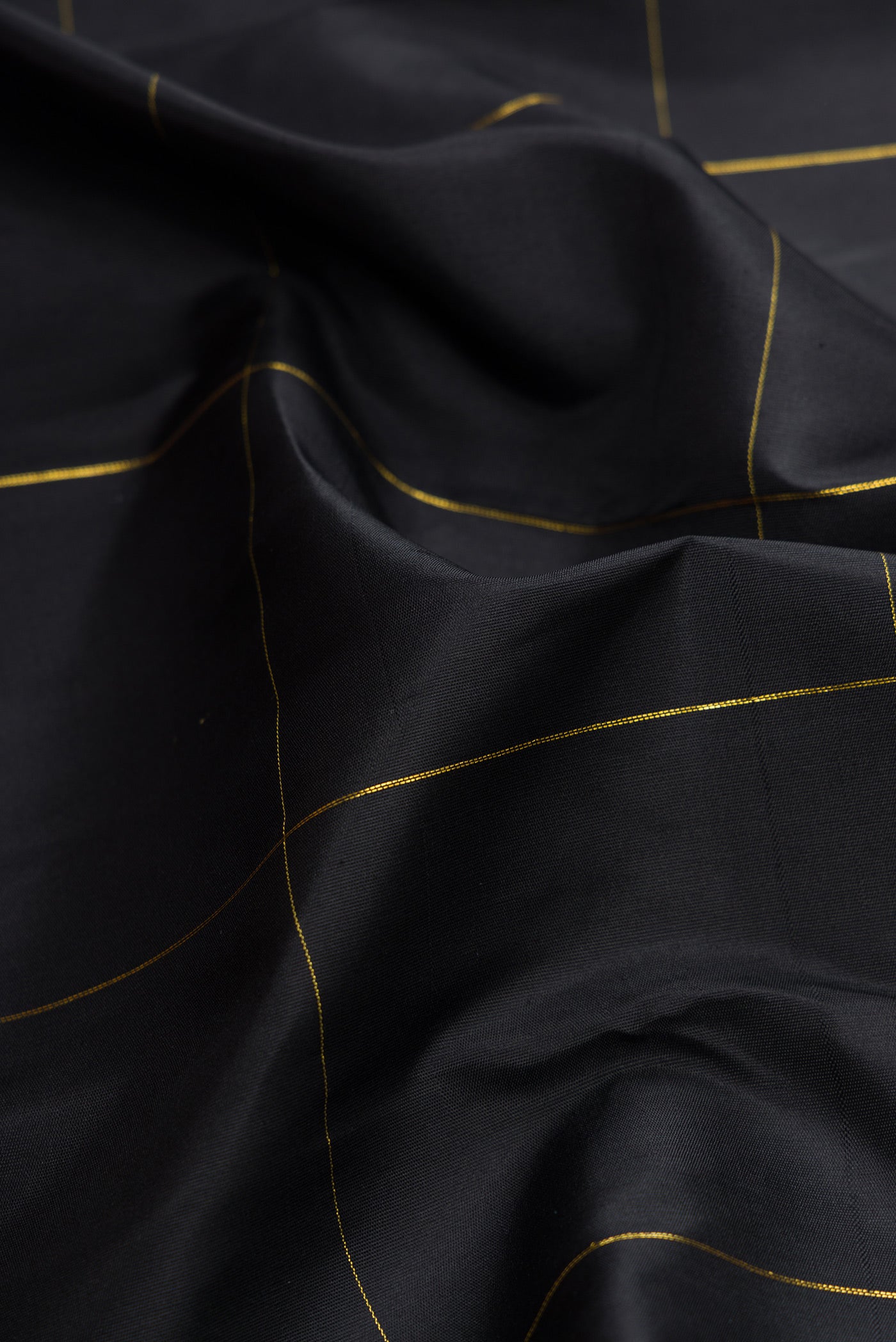 Close up of Black Dual Tone Kanchipuram Silk Saree with Checked design on the body and Fancy Border.  displaying folds