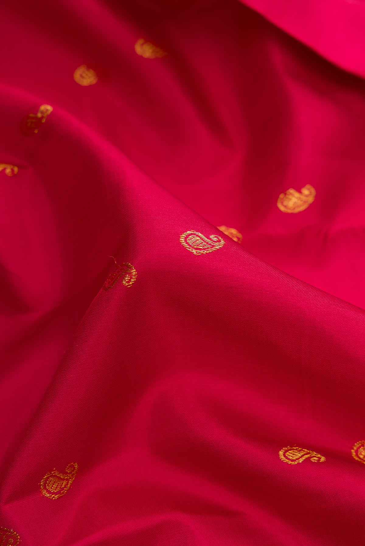Close up of Red Dual Tone Kanjivaram Silk Saree with Zari Butta on the body and Zari Border.  displaying folds