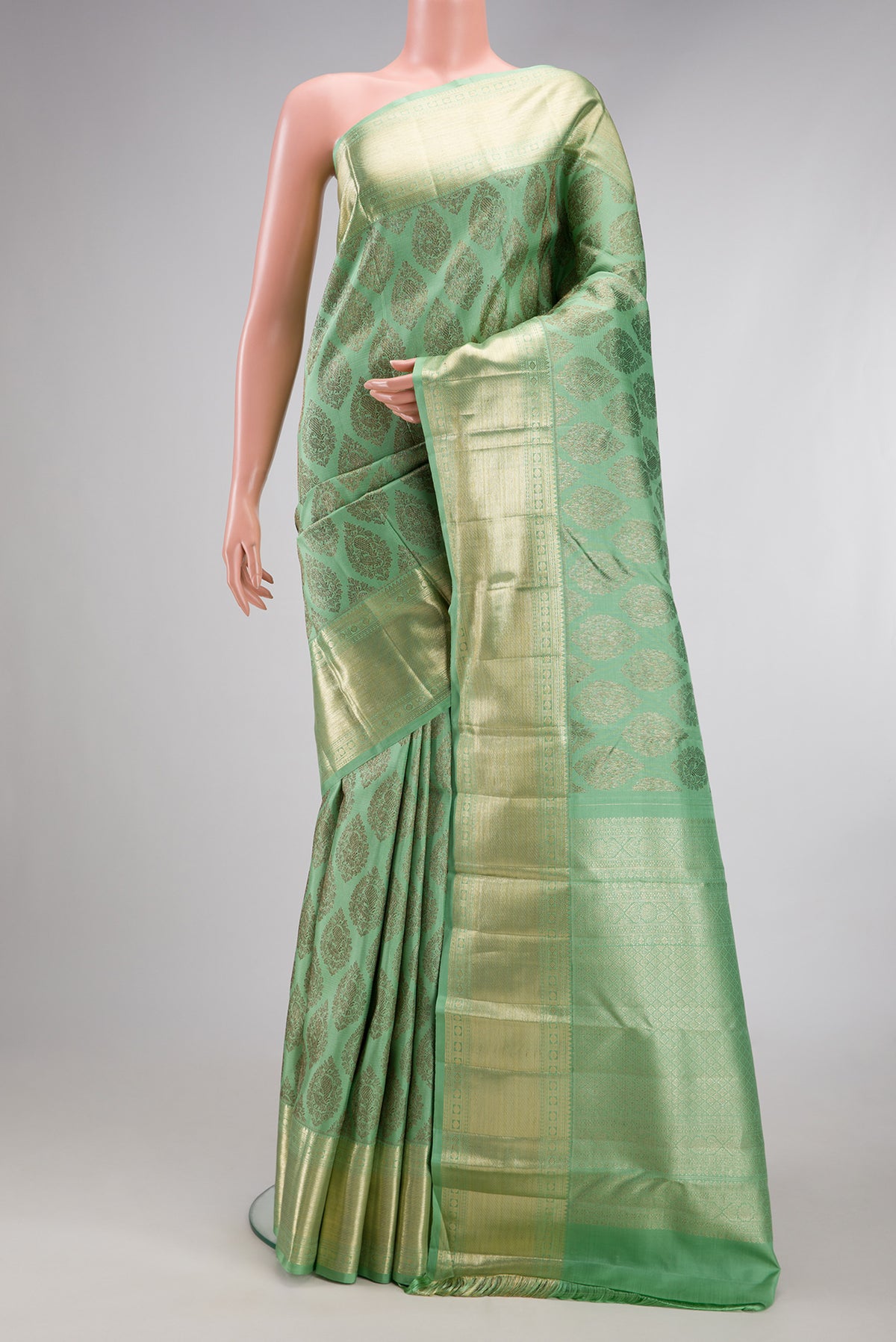 Light Green Kanchipuram Silk Saree with Zari Brocade on the body and Zari Border.  displayed on a mannequin