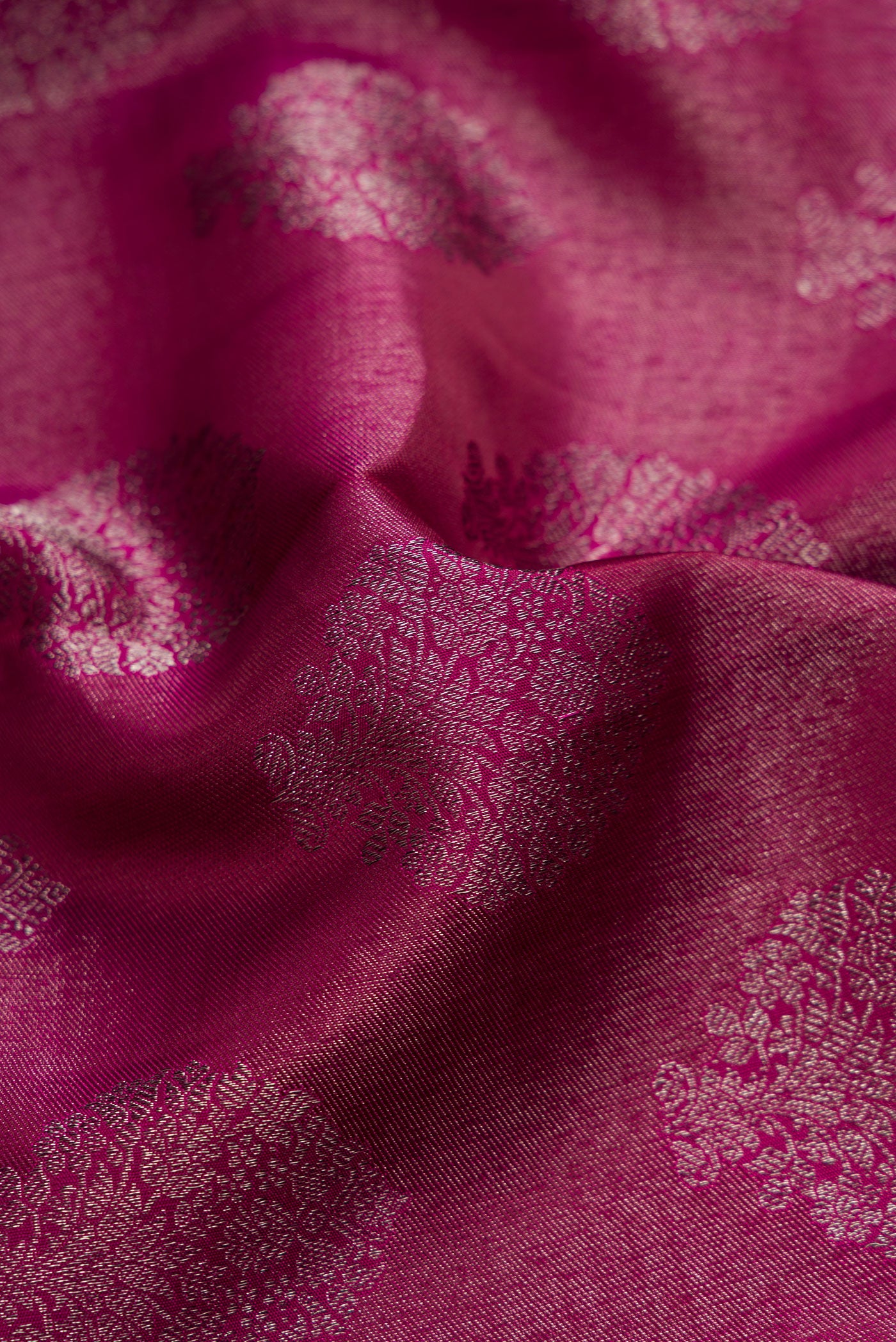 Close up of Magenta Dual Tone Kanjivaram Silk Saree with Zari Brocade on the body and Zari Border.  displaying folds