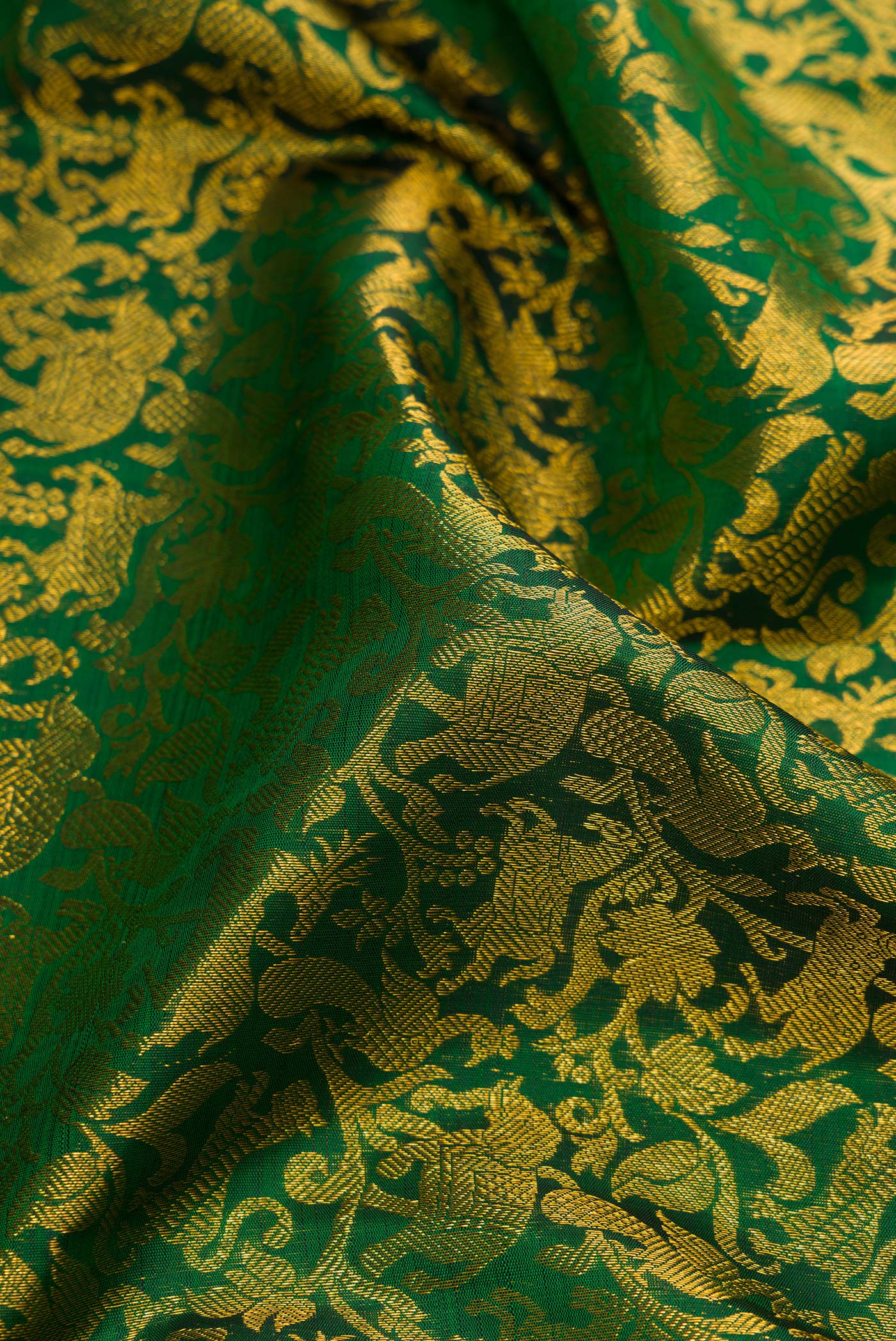 Close up of Green Dual Tone Kanchipuram Silk Saree with Zari Brocade on the body and Zari Border.  displaying folds