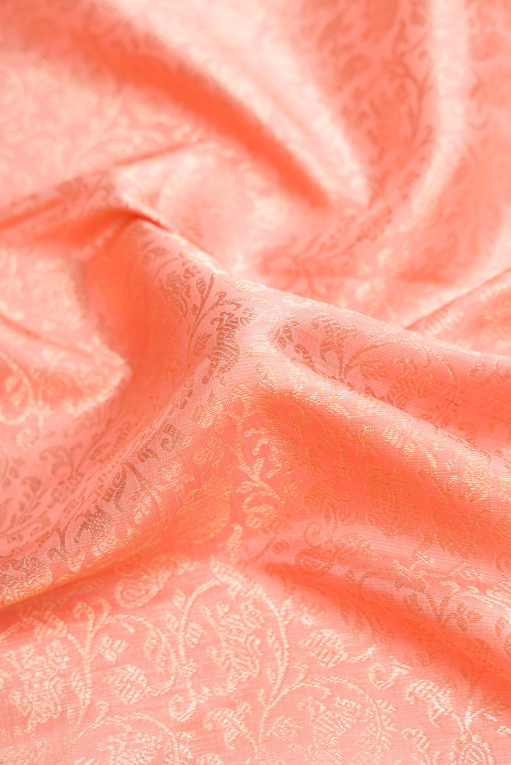 Close up of Peach Dual Tone Kanchipuram Silk Saree with Zari Brocade on the body and Zari Border.  displaying folds