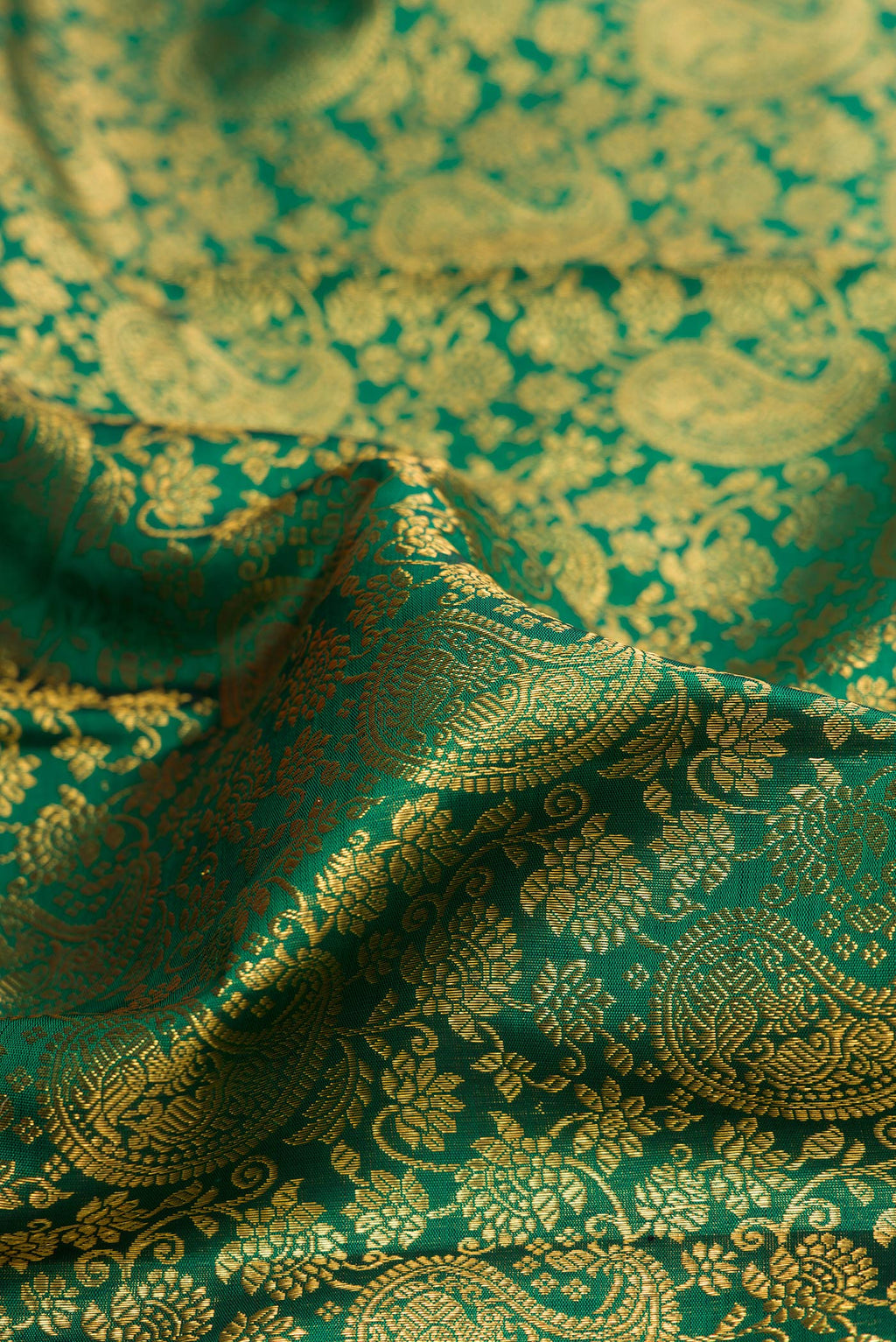 Close up of Bottle Green Kanchipuram Silk Saree with Zari Brocade on the body and Zari Border.  displaying folds