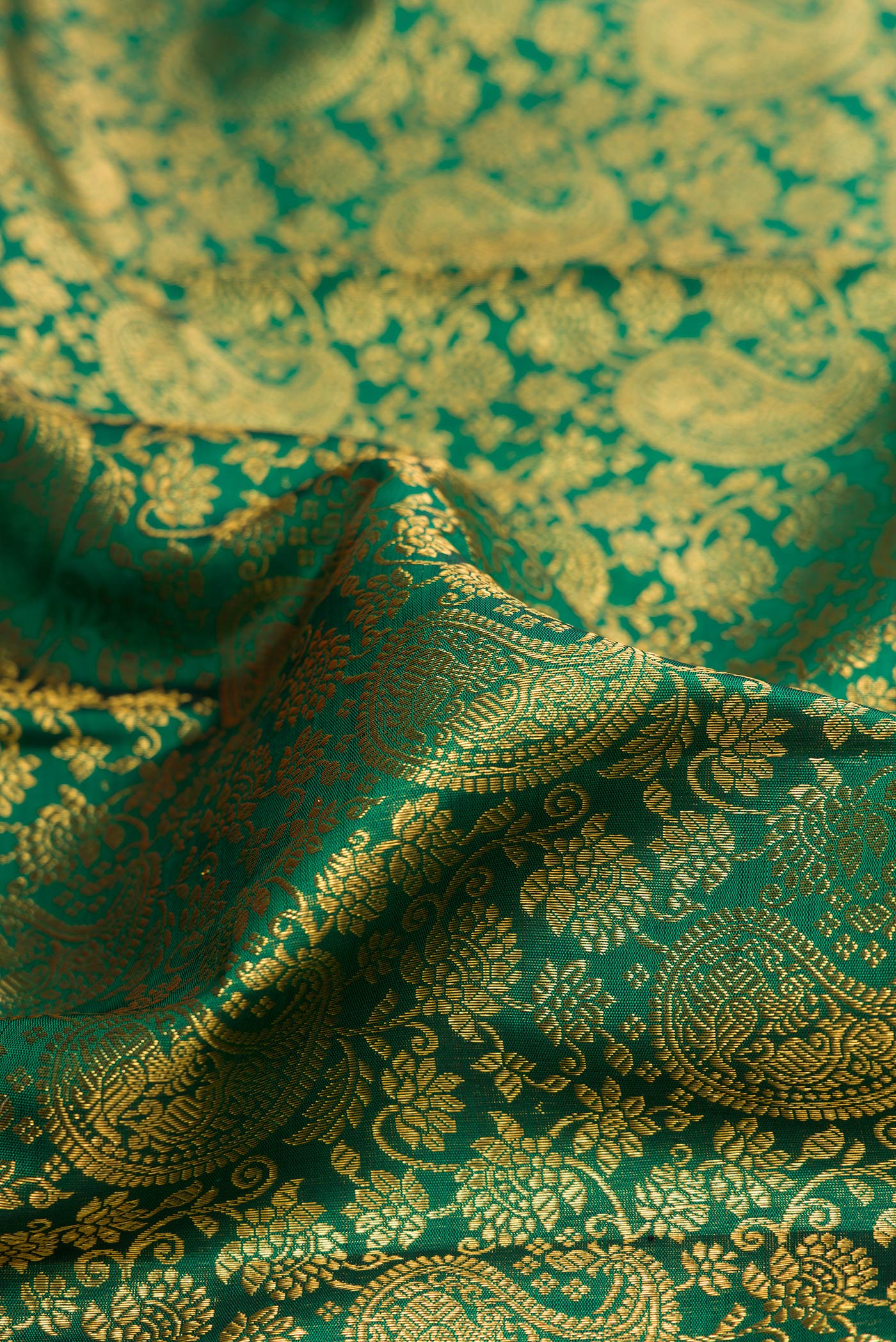 Close up of Bottle Green Kanchipuram Silk Saree with Zari Brocade on the body and Zari Border.  displaying folds