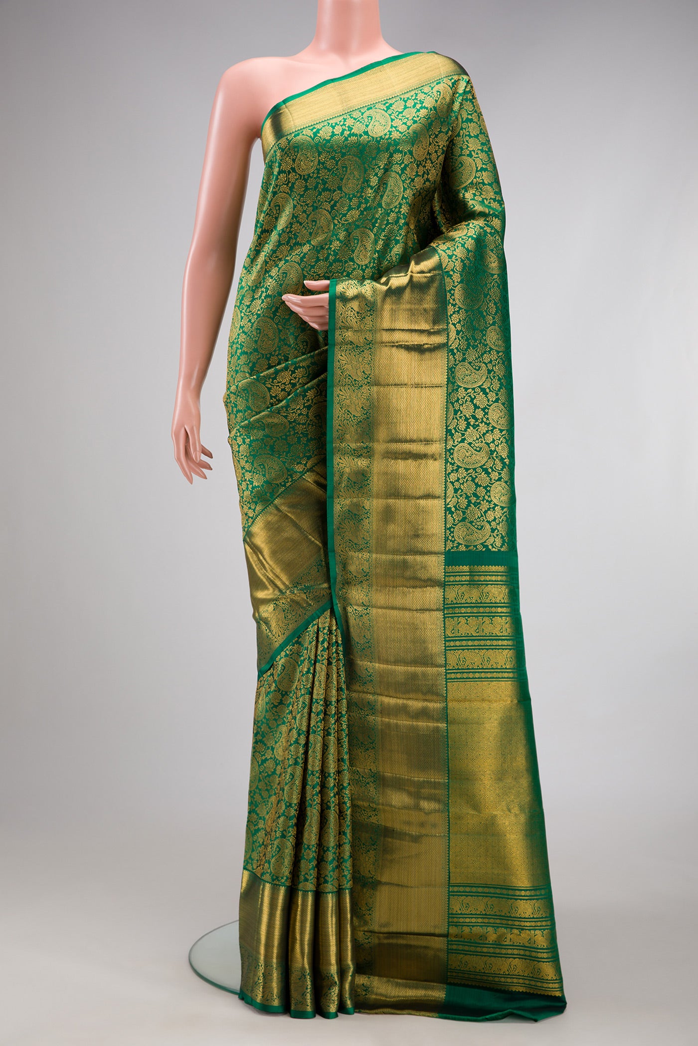 Bottle Green Kanchipuram Silk Saree with Zari Brocade on the body and Zari Border.  displayed on a mannequin