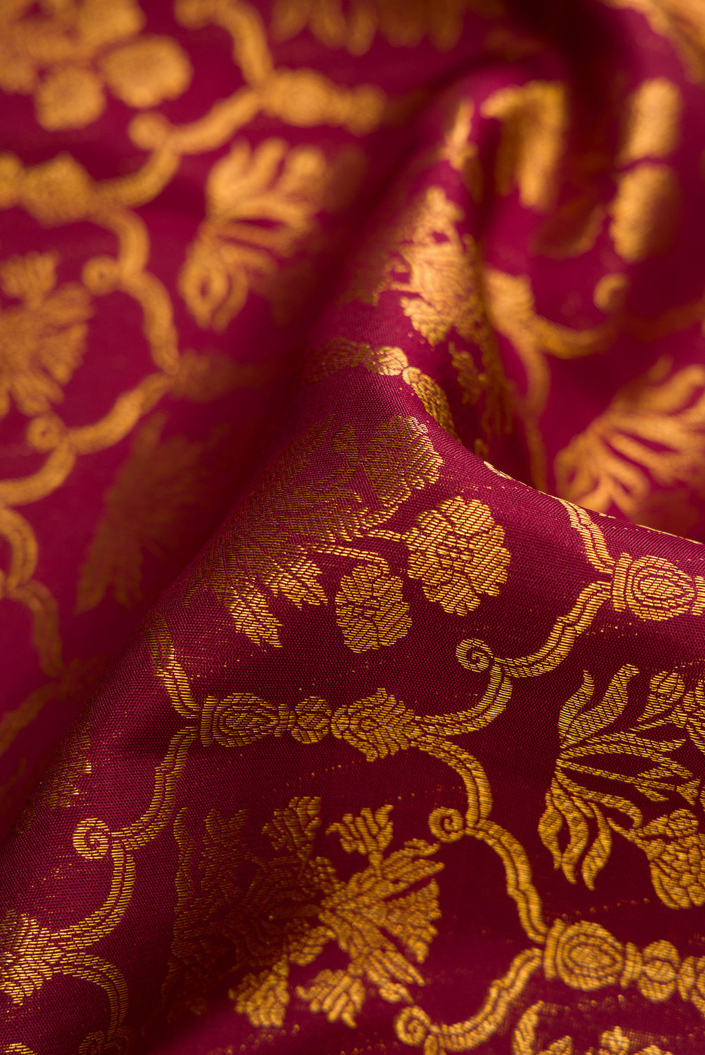Close up of Maroon Dual Tone Kanchipuram Silk Saree with Zari Brocade on the body and Zari Border.  displaying folds