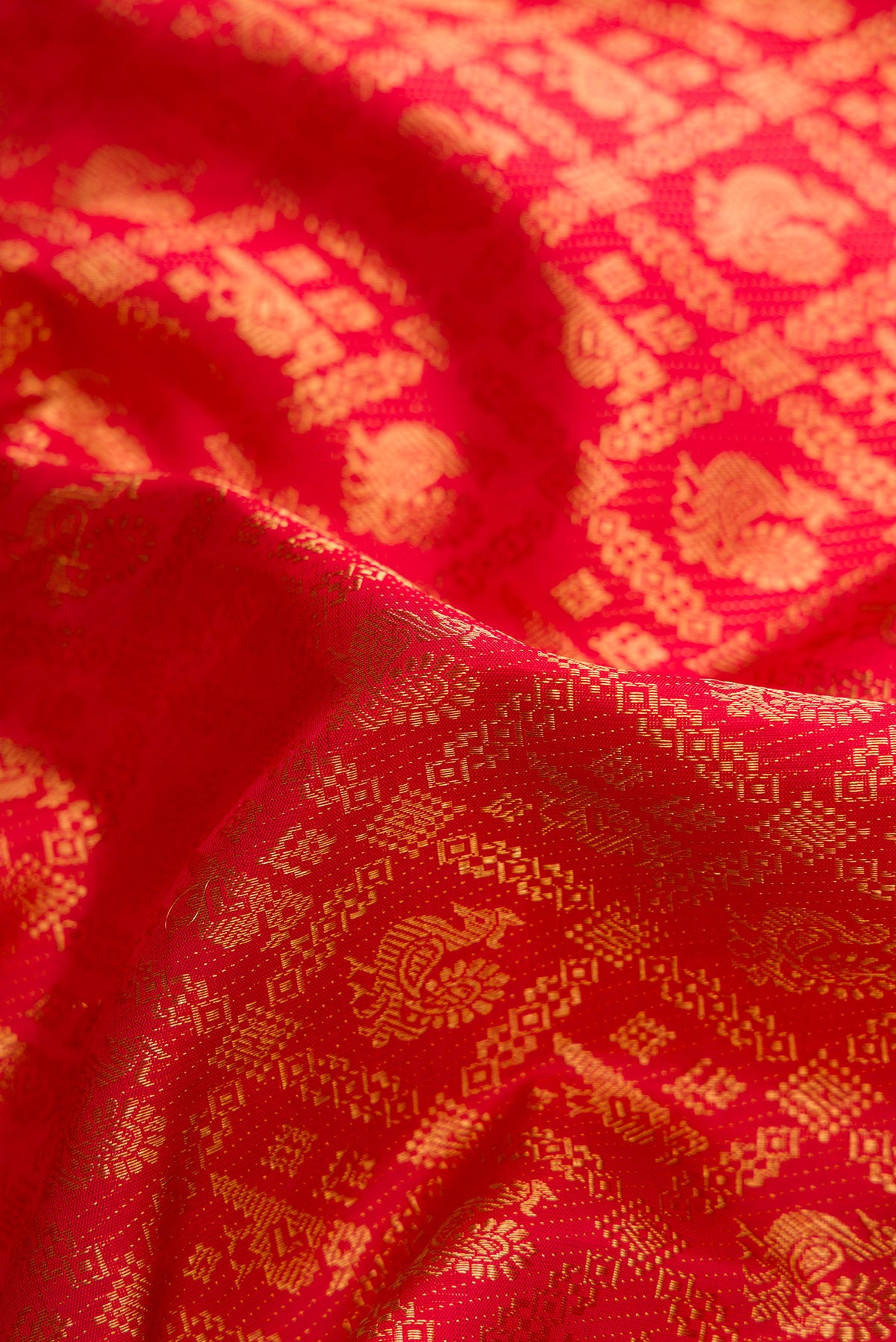 Close up of Red Dual Tone Kanjivaram Silk Saree with Zari Brocade on the body and Zari Border.  displaying folds