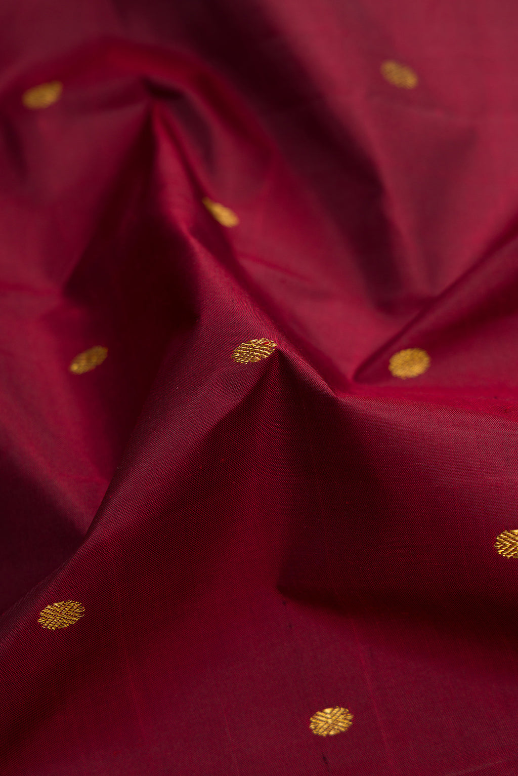 Close up of Maroon Dual Tone Kanjivaram Silk Saree with Zari Butta on the body and Zari Border.  displaying folds
