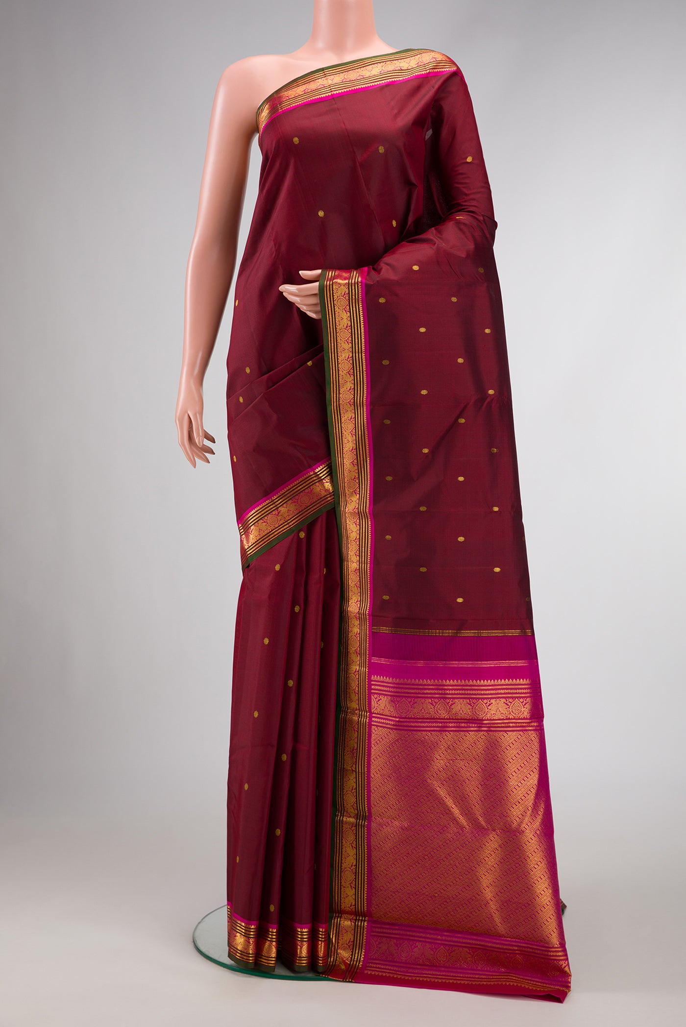 Maroon Dual Tone Kanjivaram Silk Saree with Zari Butta on the body and Zari Border.  displayed on a mannequin