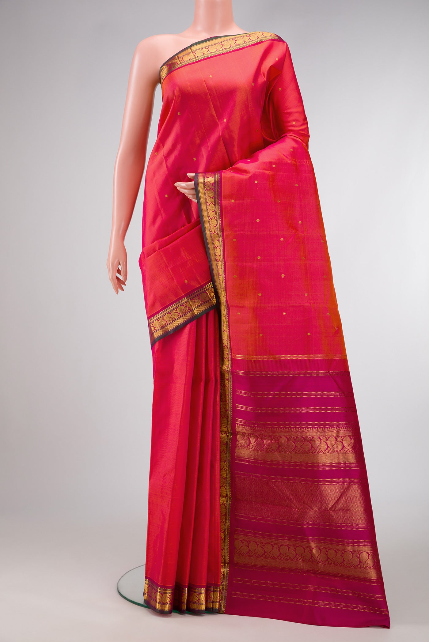 Coral Dual Tone Kanjivaram Silk Saree with Zari Butta on the body and Zari Border.  displayed on a mannequin