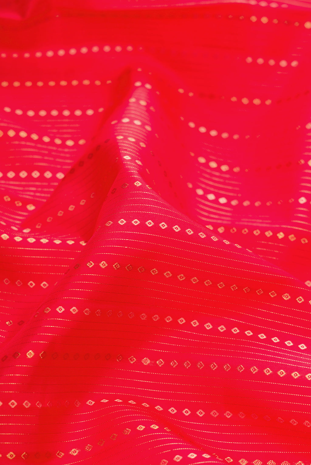 Close up of Pure Silk Pure Zari Red Dual Tone Kanchipuram Saree with Stripes on the body and Zari Border.  displaying folds