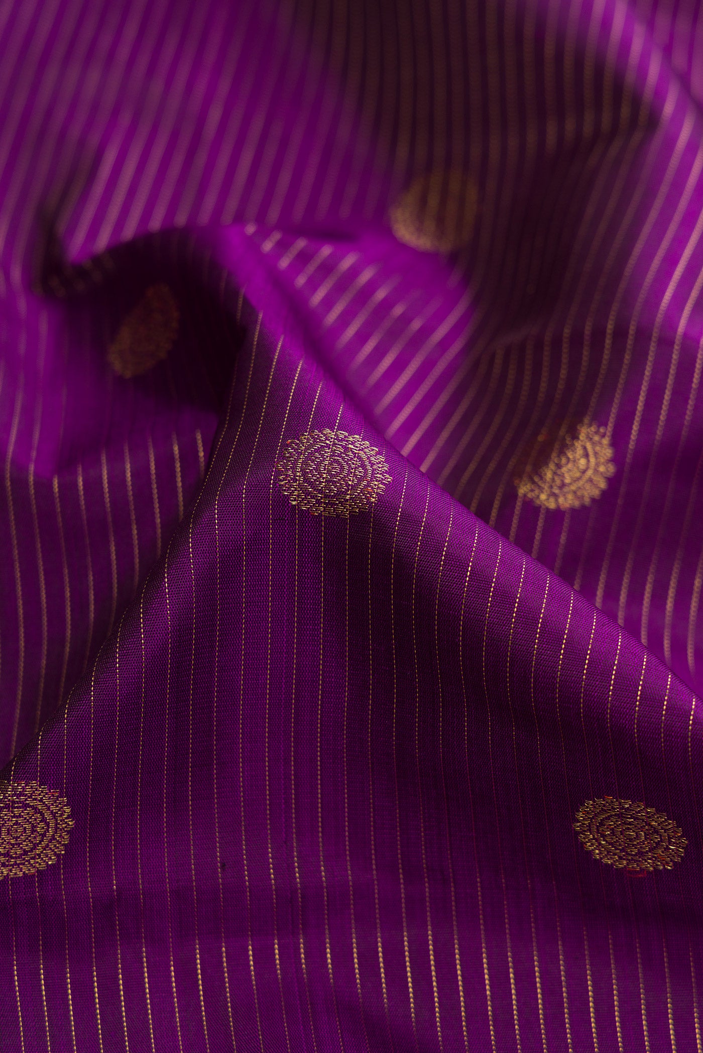 Close up of Pure Silk Pure Zari Purple Dual Tone Kanchipuram Saree with Zari Butta on the body and Without Border.  displaying folds