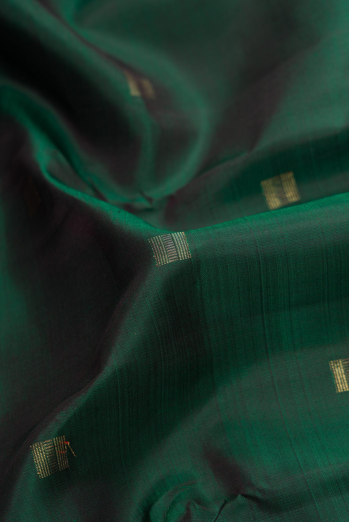 Close up of Pure Silk Pure Zari Bottle Green Dual Tone Kanchipuram Saree with Zari Butta on the body and Fancy Border.  displaying folds