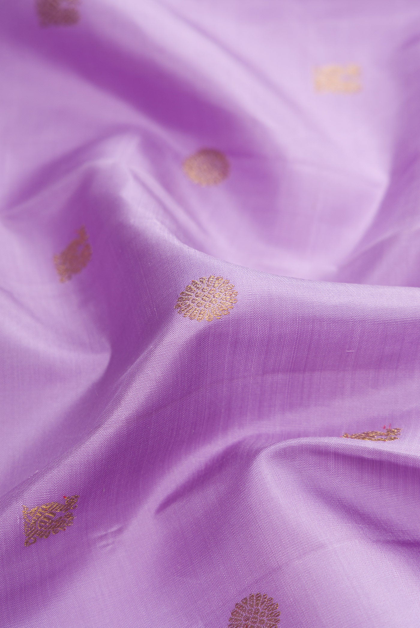 Close up of Pure Silk Pure Zari Lavender Dual Tone Kanchipuram Saree with Zari Butta on the body and Temple Border.  displaying folds