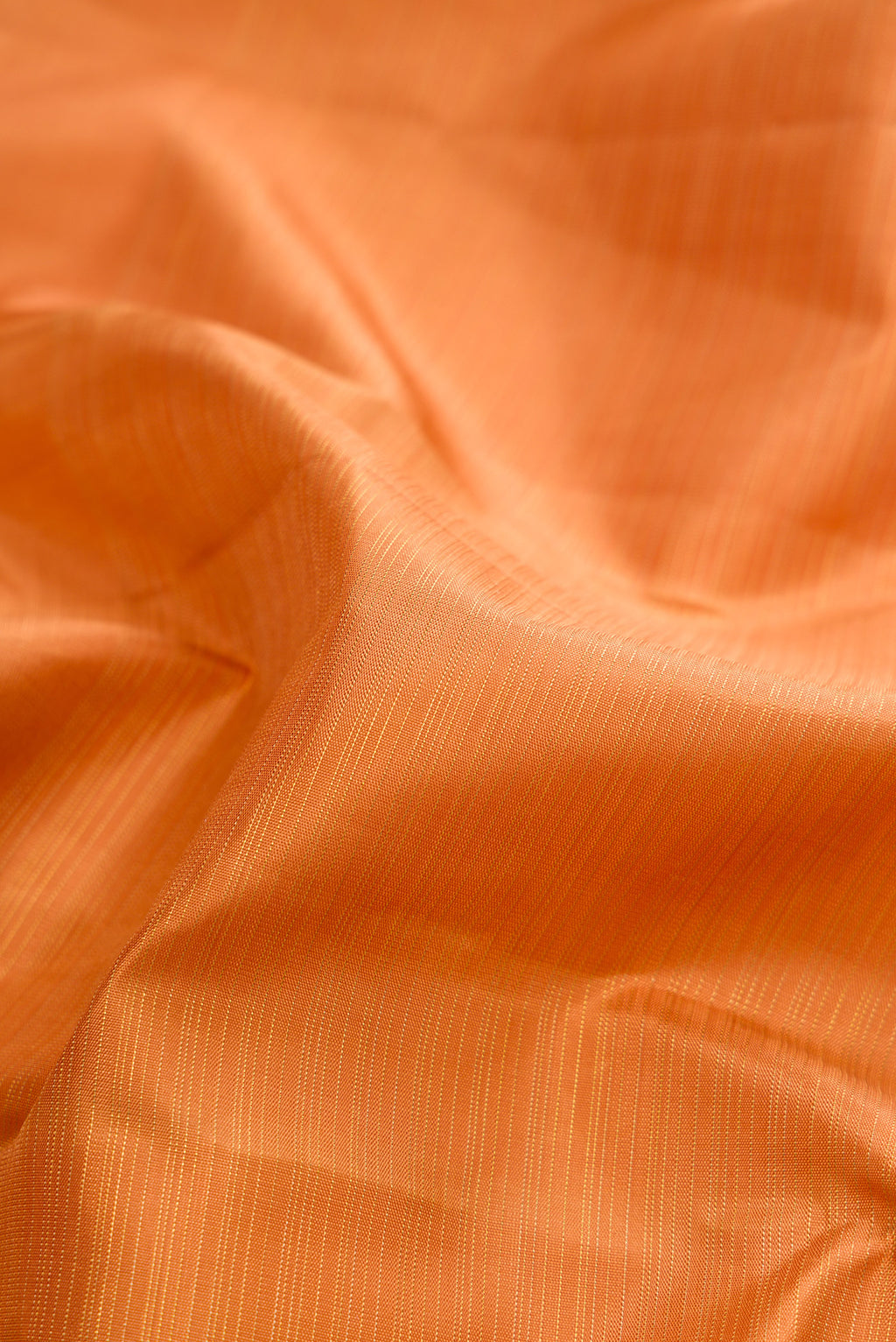 Close up of Pure Silk Pure Zari Golden Dual Tone Kanchipuram Saree with Zari Butta on the body and Without Border.  displaying folds