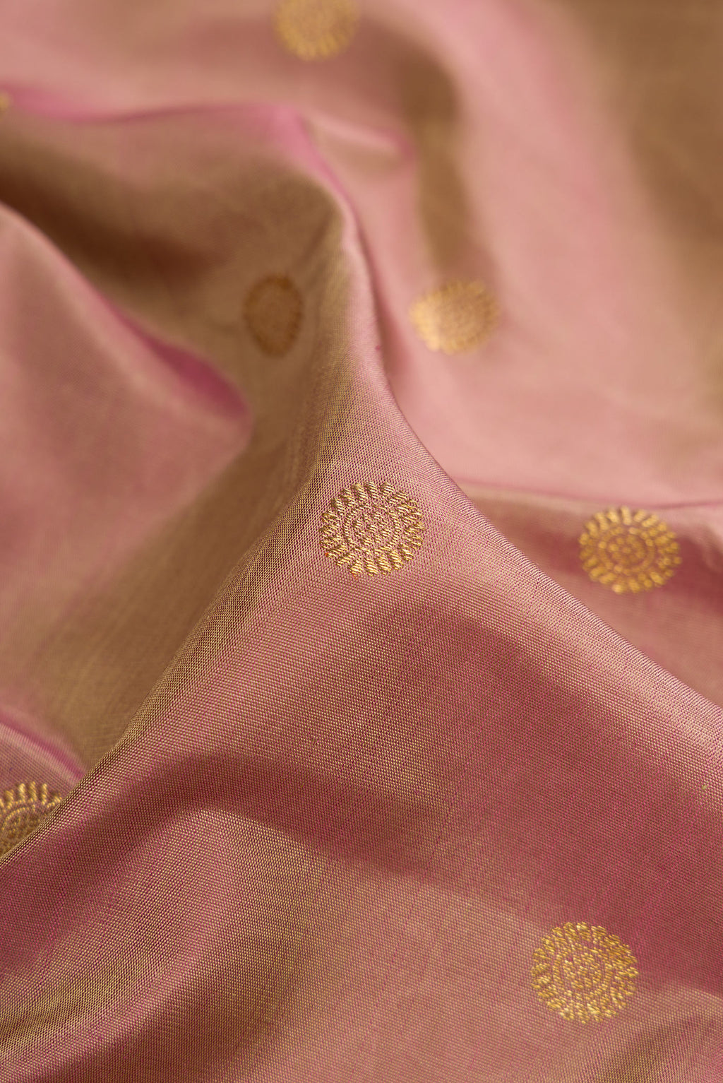 Close up of Pure Silk Pure Zari Rose Gold Kanjivaram Saree with Zari Butta on the body and Zari Border.  displaying folds