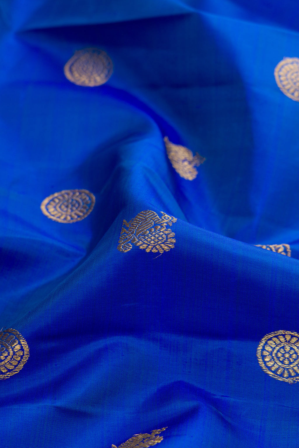 Close up of Pure Silk Pure Zari Royal Blue Dual Tone Kanjivaram Saree with Zari Butta on the body and Zari Border.  displaying folds