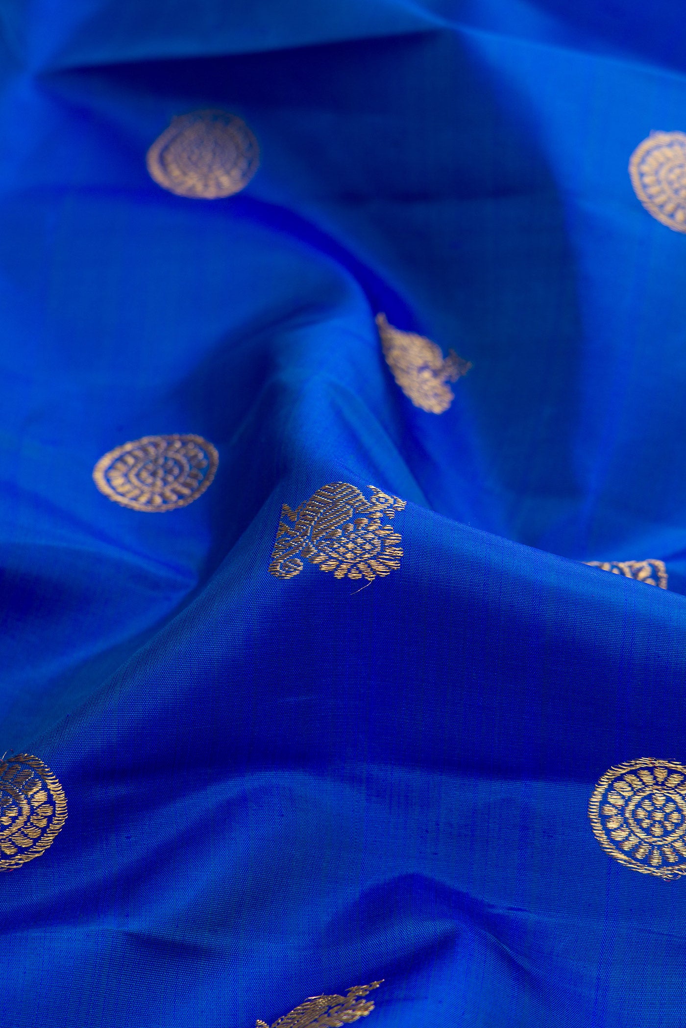 Close up of Pure Silk Pure Zari Royal Blue Dual Tone Kanjivaram Saree with Zari Butta on the body and Zari Border.  displaying folds