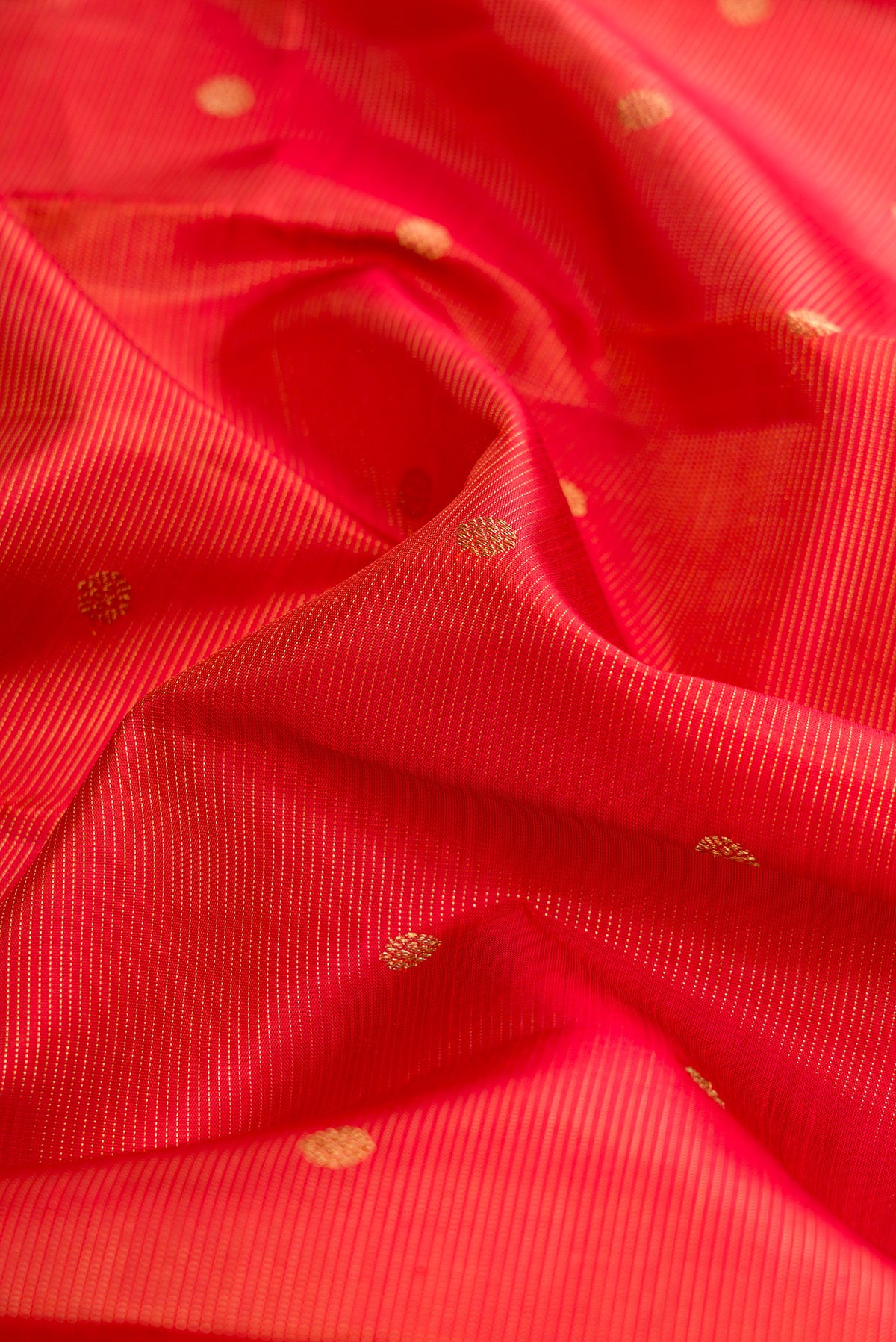 Close up of Pure Silk Pure Zari Brick Orange Dual Tone Kanjivaram Saree with Stripes on the body and Zari Border.  displaying folds
