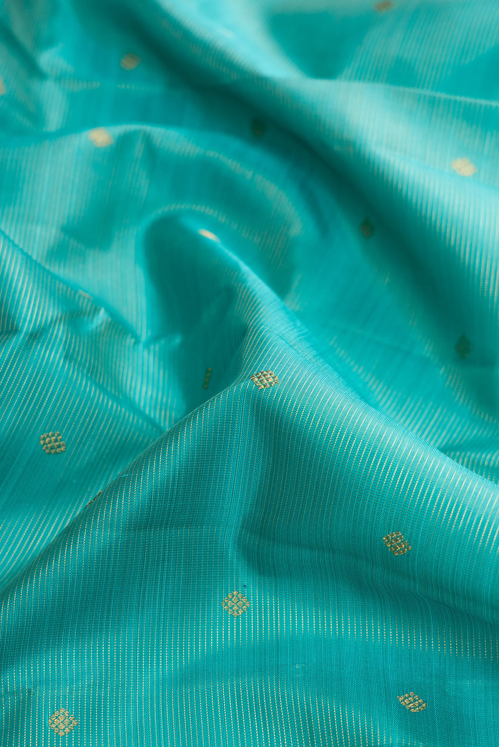 Close up of Pure Silk Pure Zari Light Blue Dual Tone Kanjivaram Saree with Stripes on the body and Zari Border.  displaying folds