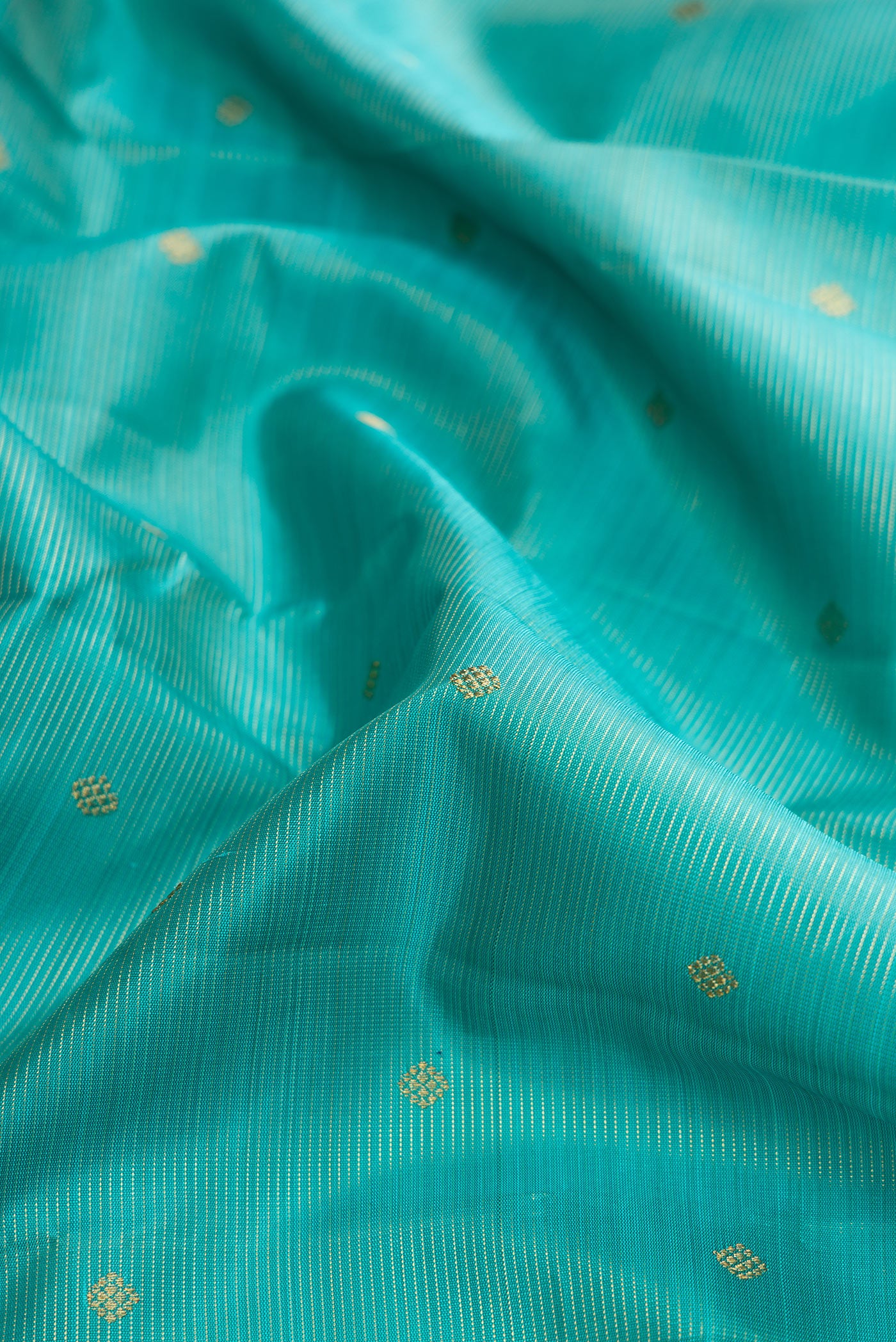 Close up of Pure Silk Pure Zari Light Blue Dual Tone Kanjivaram Saree with Stripes on the body and Zari Border.  displaying folds