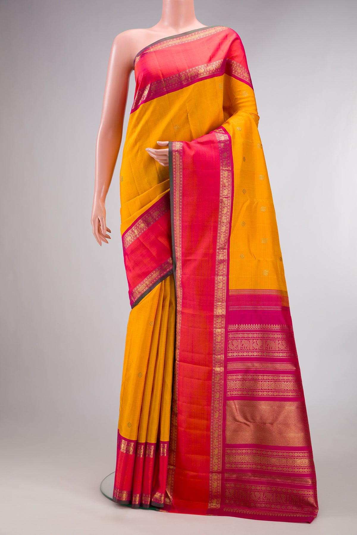 Pure Silk Pure Zari Mustard Kanjivaram Saree with Zari Butta on the body and Zari Border.  displayed on a mannequin