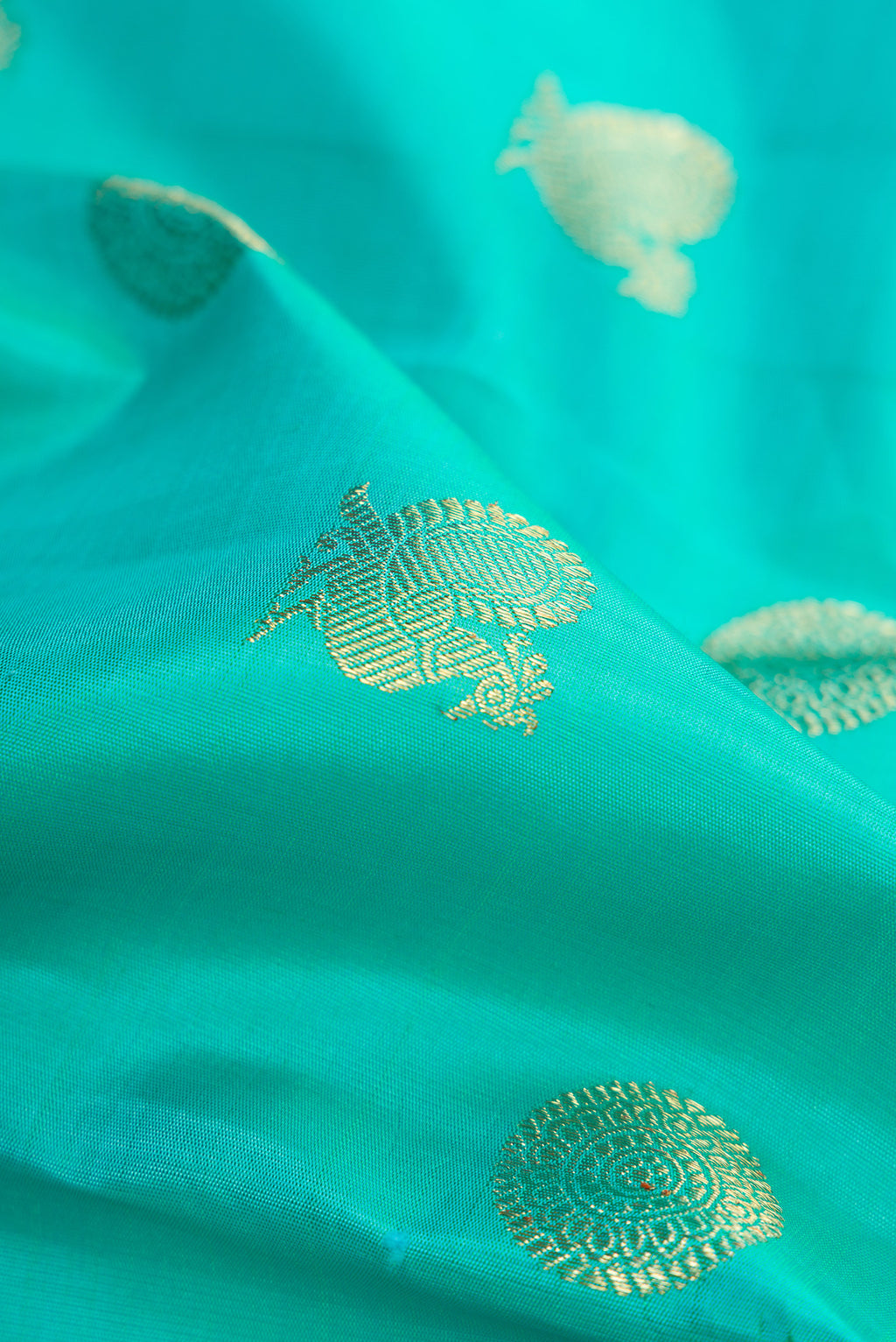 Close up of Pure Silk Pure Zari Sky Blue Dual Tone Kanjivaram Saree with Zari Butta on the body and Zari Border.  displaying folds