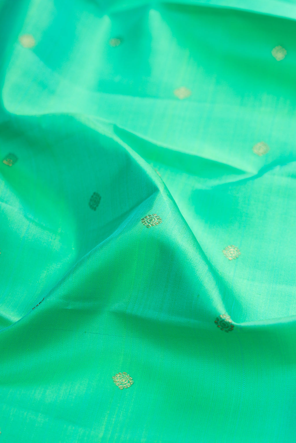 Close up of Pure Silk Pure Zari Sea Green Kanjivaram Saree with Zari Butta on the body and Zari Border.  displaying folds