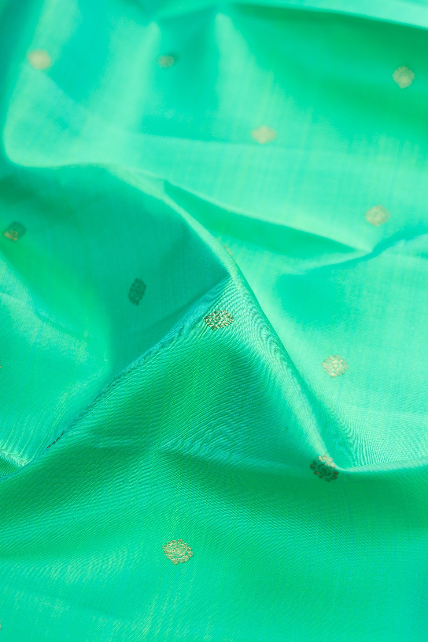 Close up of Pure Silk Pure Zari Sea Green Kanjivaram Saree with Zari Butta on the body and Zari Border.  displaying folds