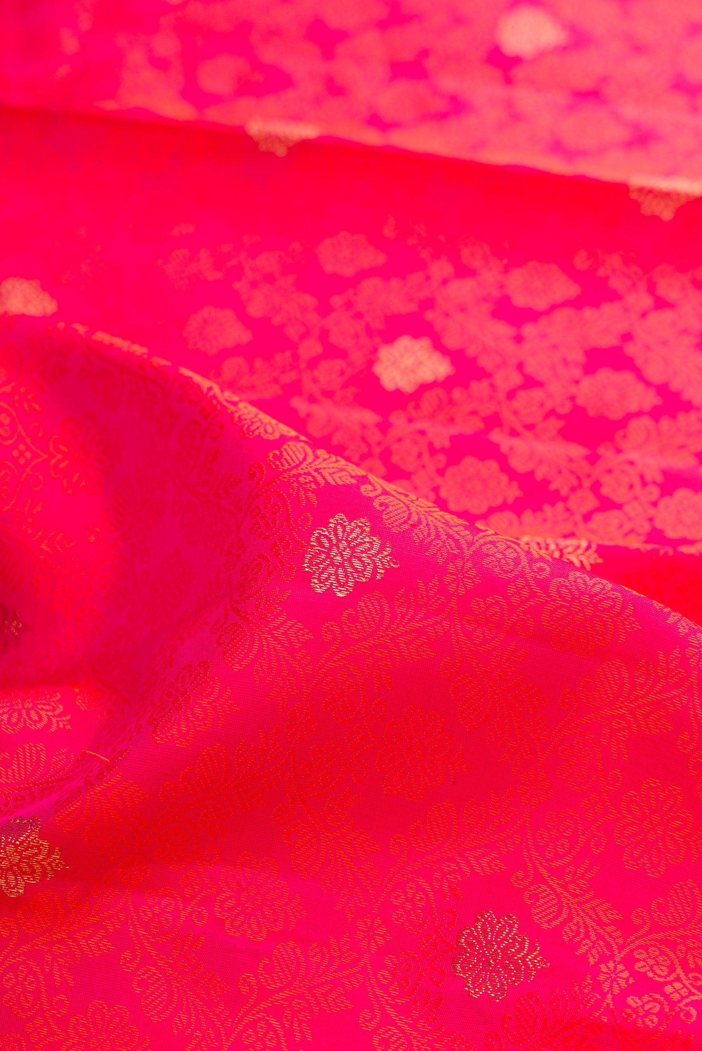 Close up of Pure Silk Pure Zari Pink Dual Tone Kanjivaram Saree with Jacquard With Zari Butta on the body and Zari Border.  displaying folds