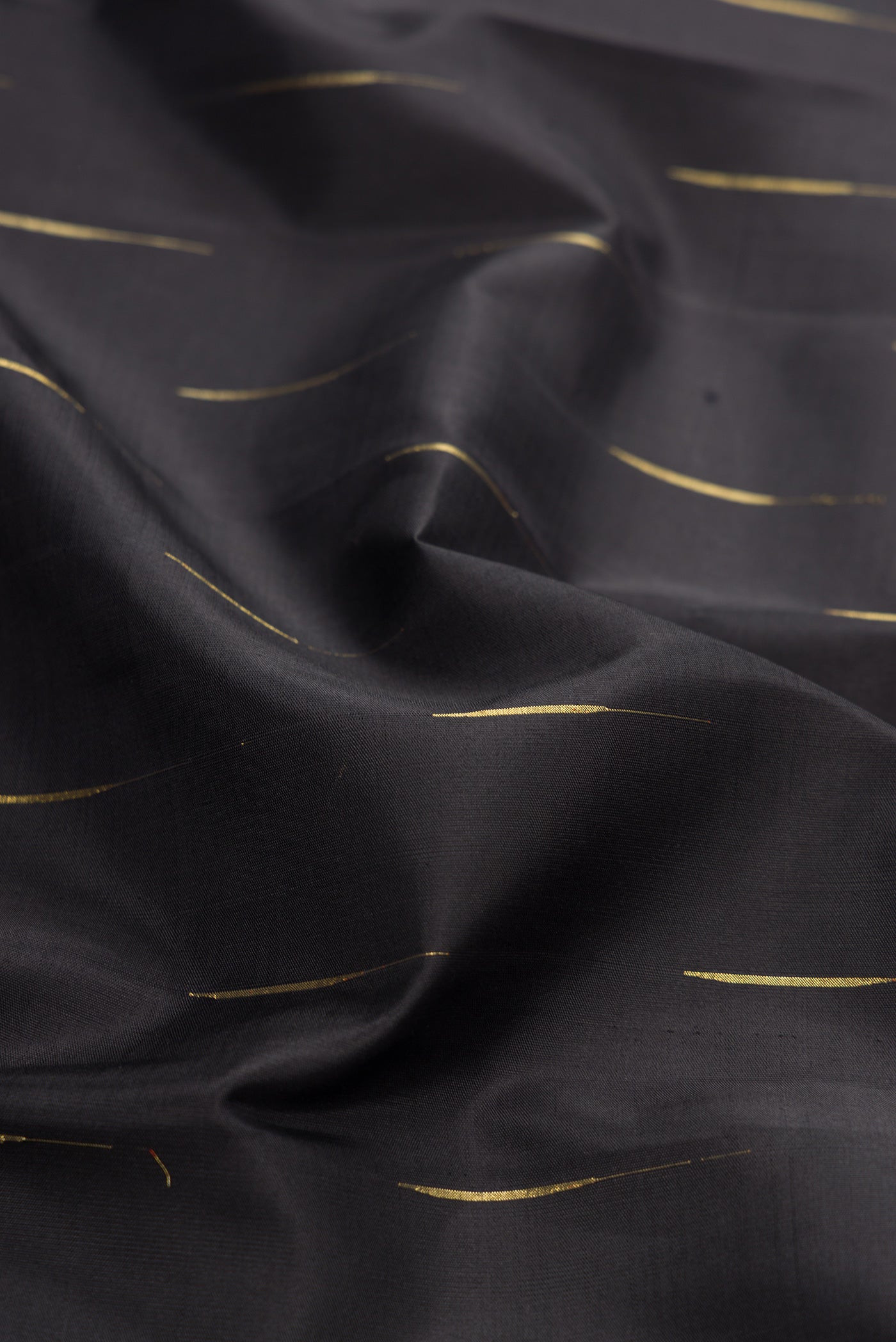 Close up of Black Dual Tone Kanjivaram Silk Saree with Zari Butta on the body and Zari Border.  displaying folds