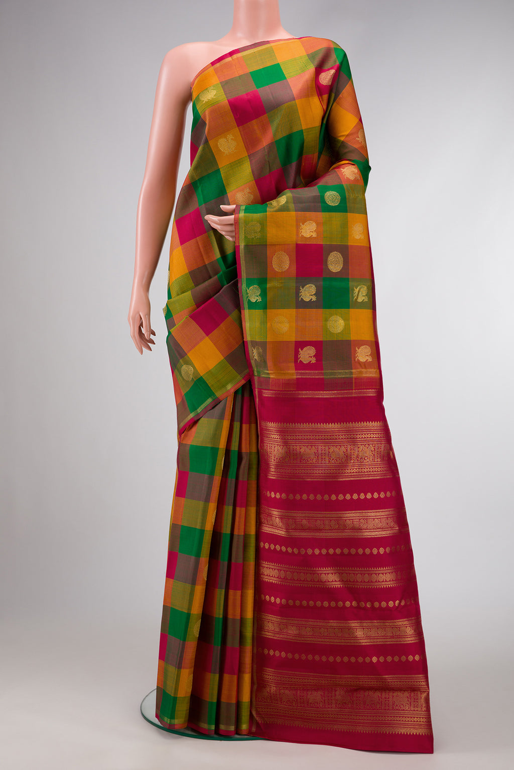 Green, Red and Mustard Color Kanchipuram Silk Saree with Checked design on the body and Without Border.  displayed on a mannequin