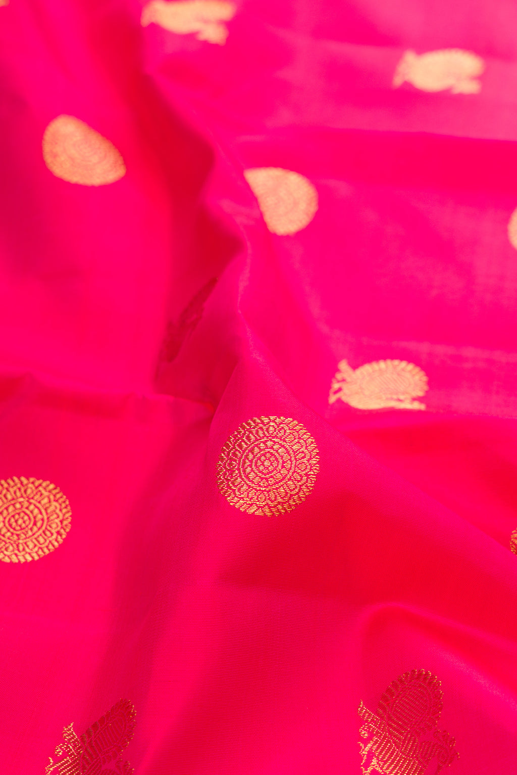 Close up of Pure Silk Pure Zari Pink Kanchipuram Saree with Zari Butta on the body and Zari Border.  displaying folds