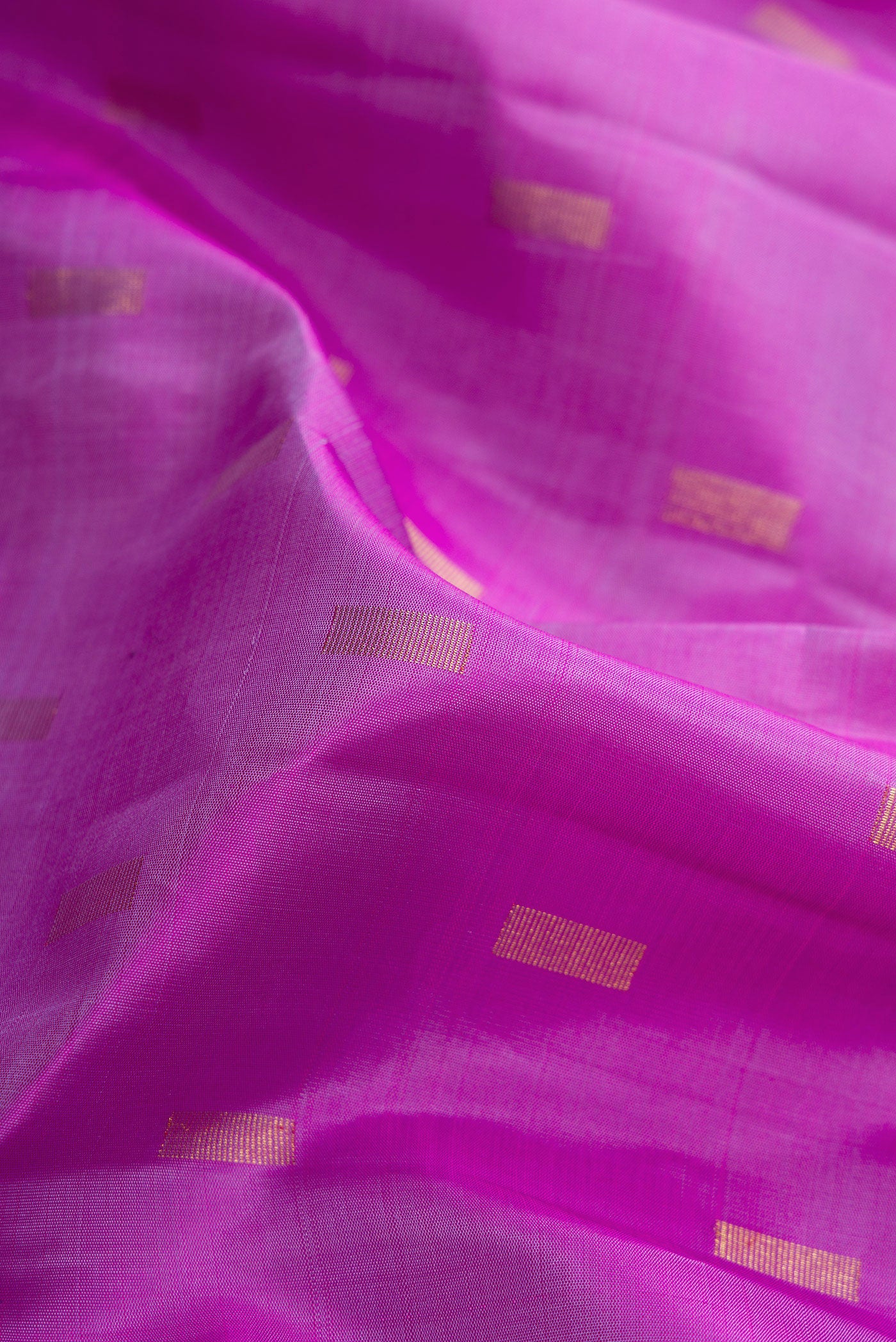 Close up of Pure Silk Pure Zari Purple Dual Tone Kanjivaram Saree with Zari Butta on the body and Zari Border.  displaying folds