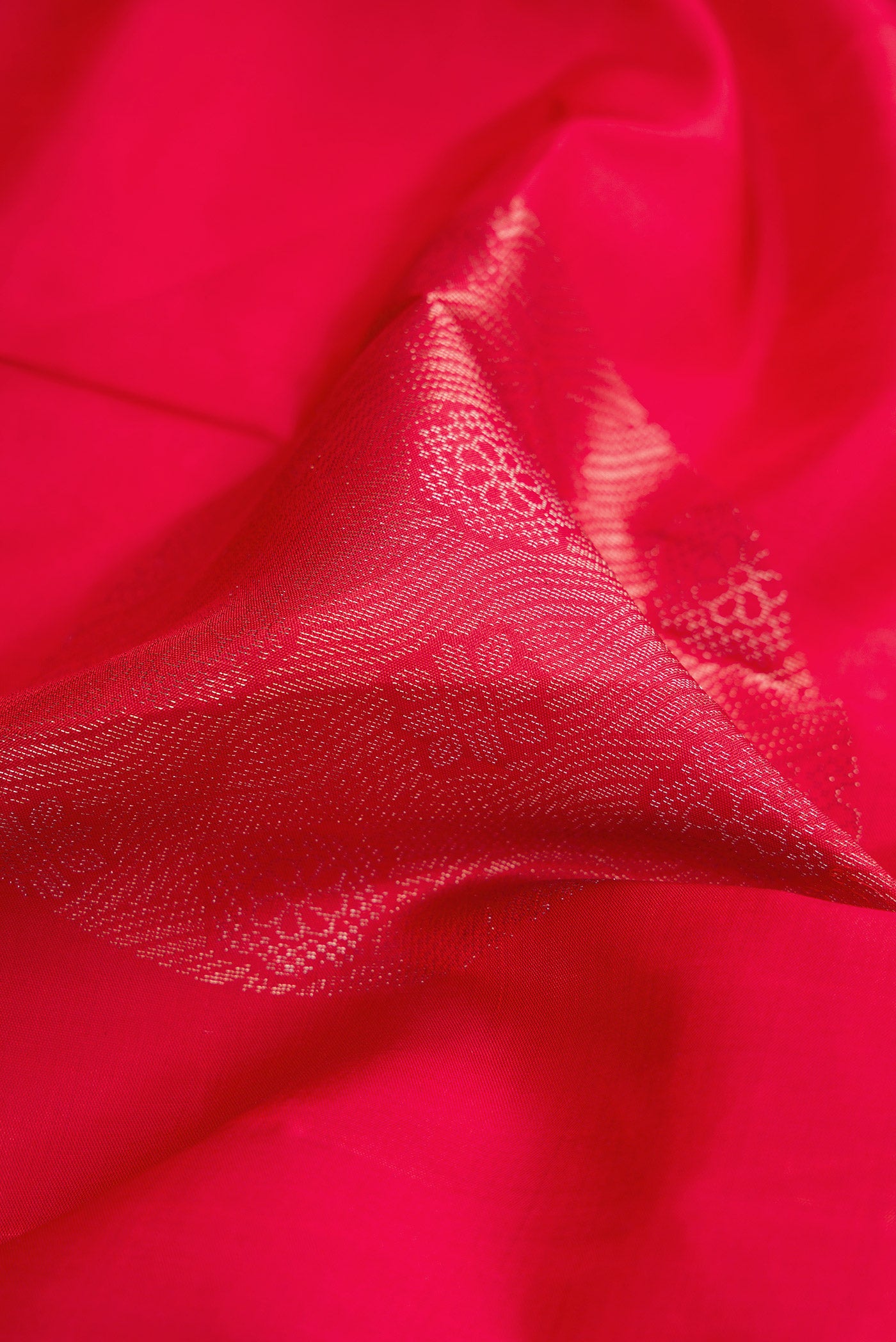 Close up of Red Dual Tone Soft Silk Saree with Zari Butta on the body and Without Border.  displaying folds