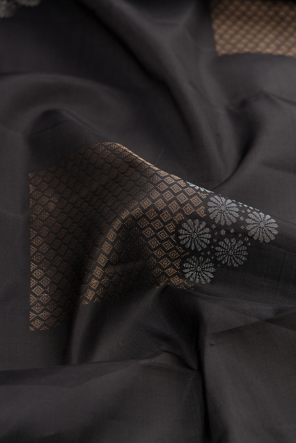 Close up of Black Dual Tone Soft Silk Saree with Zari Butta on the body and Without Border.  displaying folds