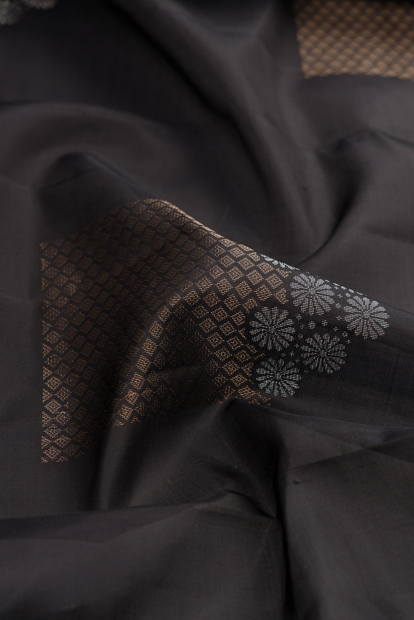 Close up of Black Dual Tone Soft Silk Saree with Zari Butta on the body and Without Border.  displaying folds