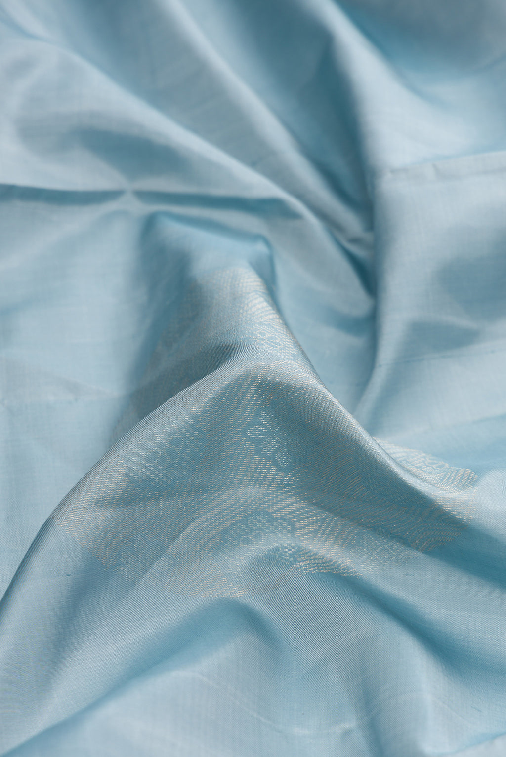 Close up of Grey Dual Tone Soft Silk Saree with Zari Butta on the body and Without Border.  displaying folds