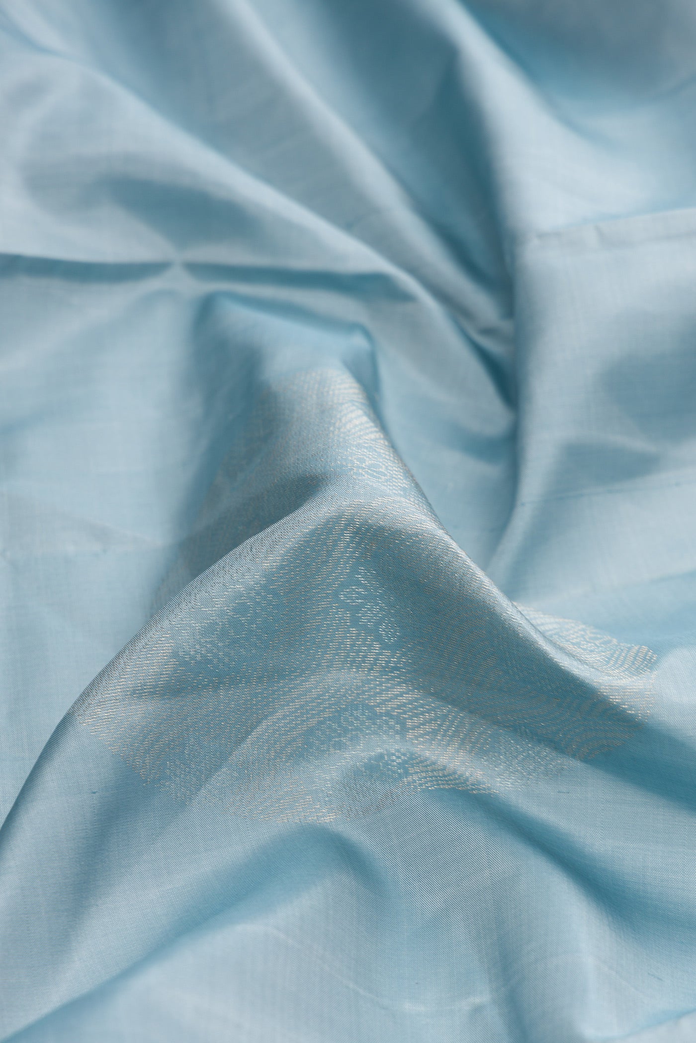 Close up of Grey Dual Tone Soft Silk Saree with Zari Butta on the body and Without Border.  displaying folds