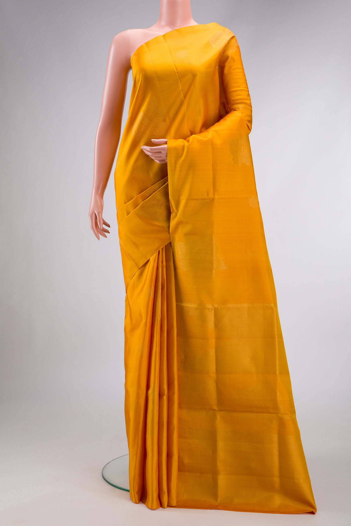 Mustard Dual Tone Soft Silk Saree with Zari Butta on the body and Fancy Border.  displayed on a mannequin