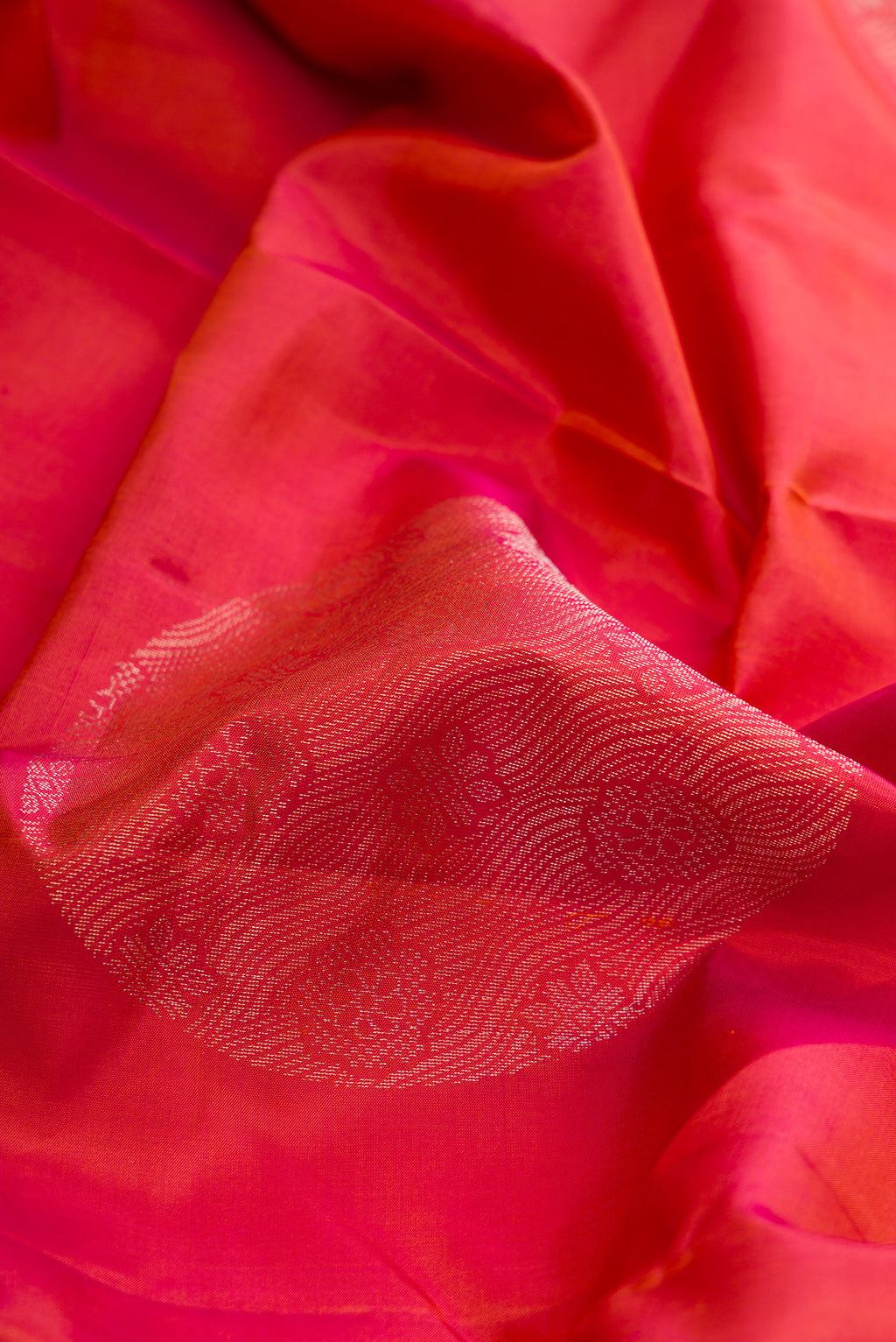 Close up of Brick Orange Dual Tone Soft Silk Saree with Zari Butta on the body and Without Border.  displaying folds