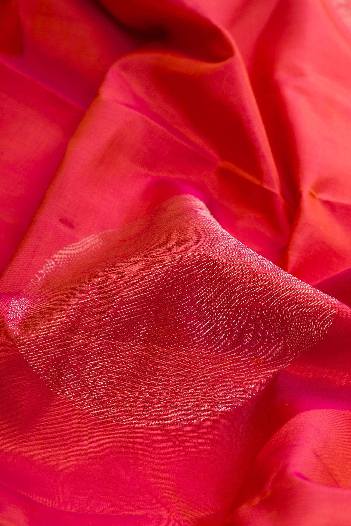 Close up of Brick Orange Dual Tone Soft Silk Saree with Zari Butta on the body and Without Border.  displaying folds
